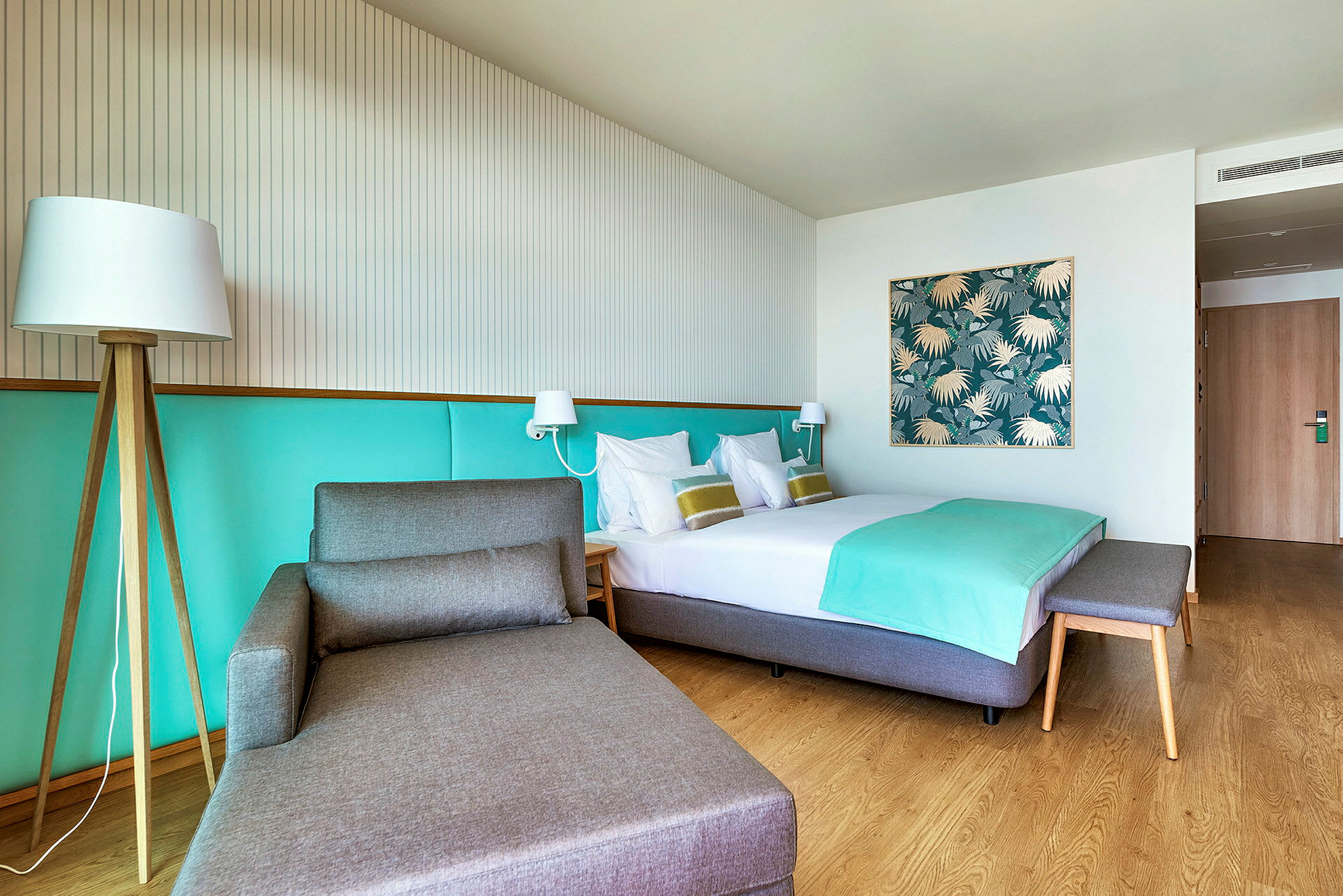 Hotellrom med en seng, en sittemøbel og lys dekor. (AI-generert tekst)