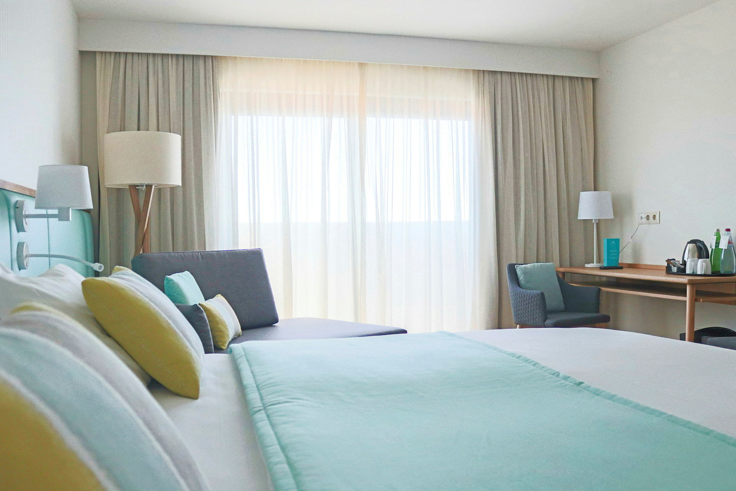 Moderne hotellrom med en dobbeltseng, sofa og skrivebord. (AI-generert tekst)