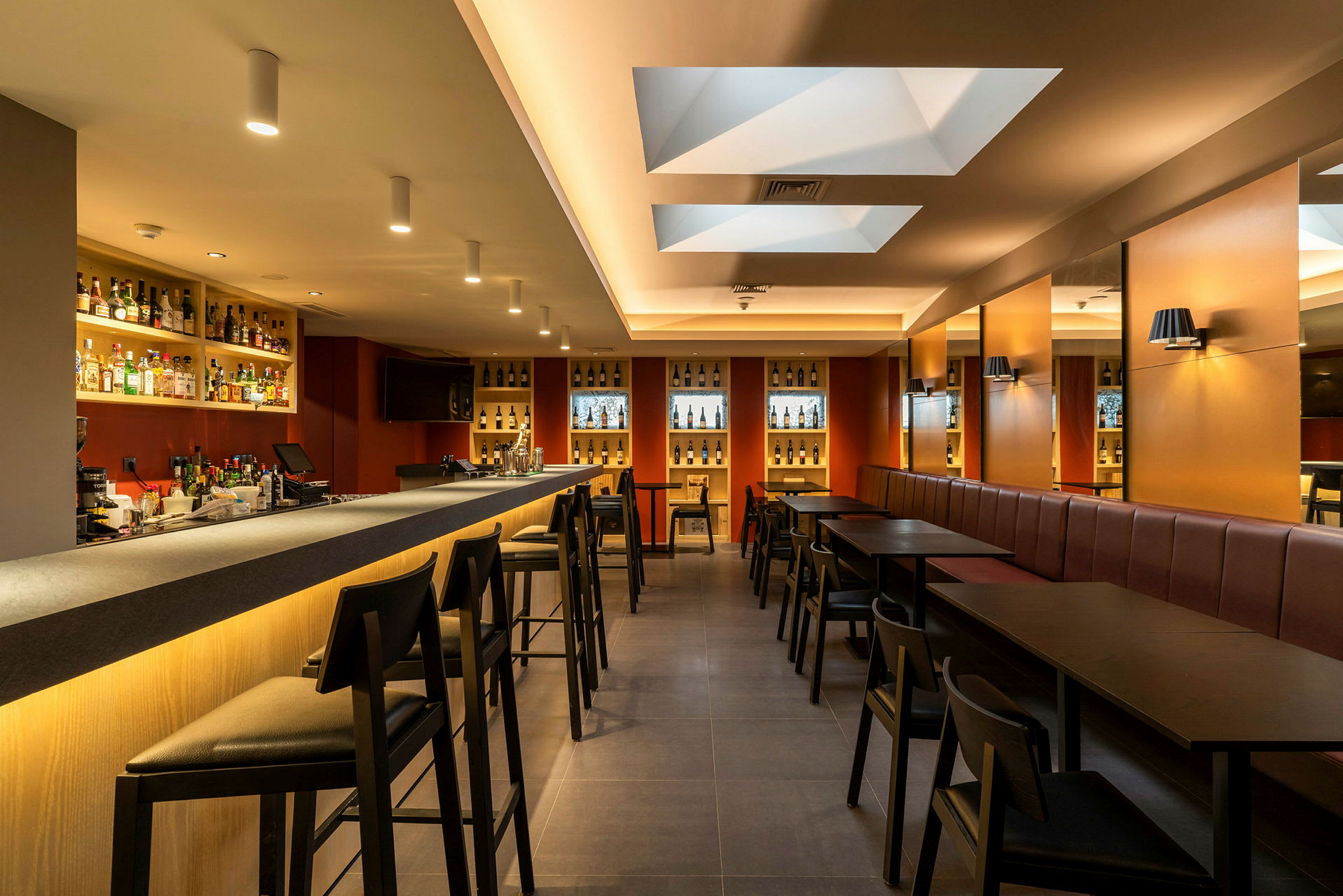 Interiør av en moderne bar med bardisk, stoler og bord. (AI-generert tekst)