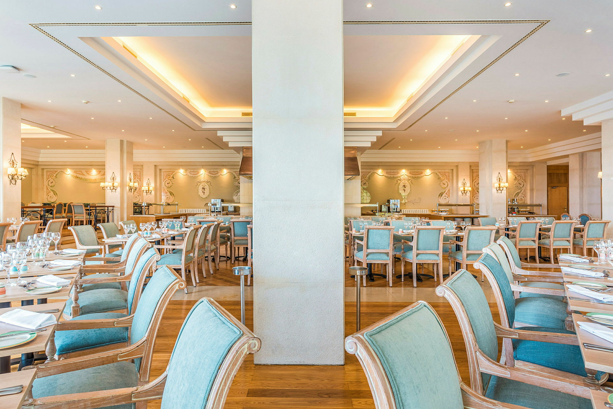 Stoler og bord satt opp i en elegant restaurant med lys innredning. (AI-generert tekst)