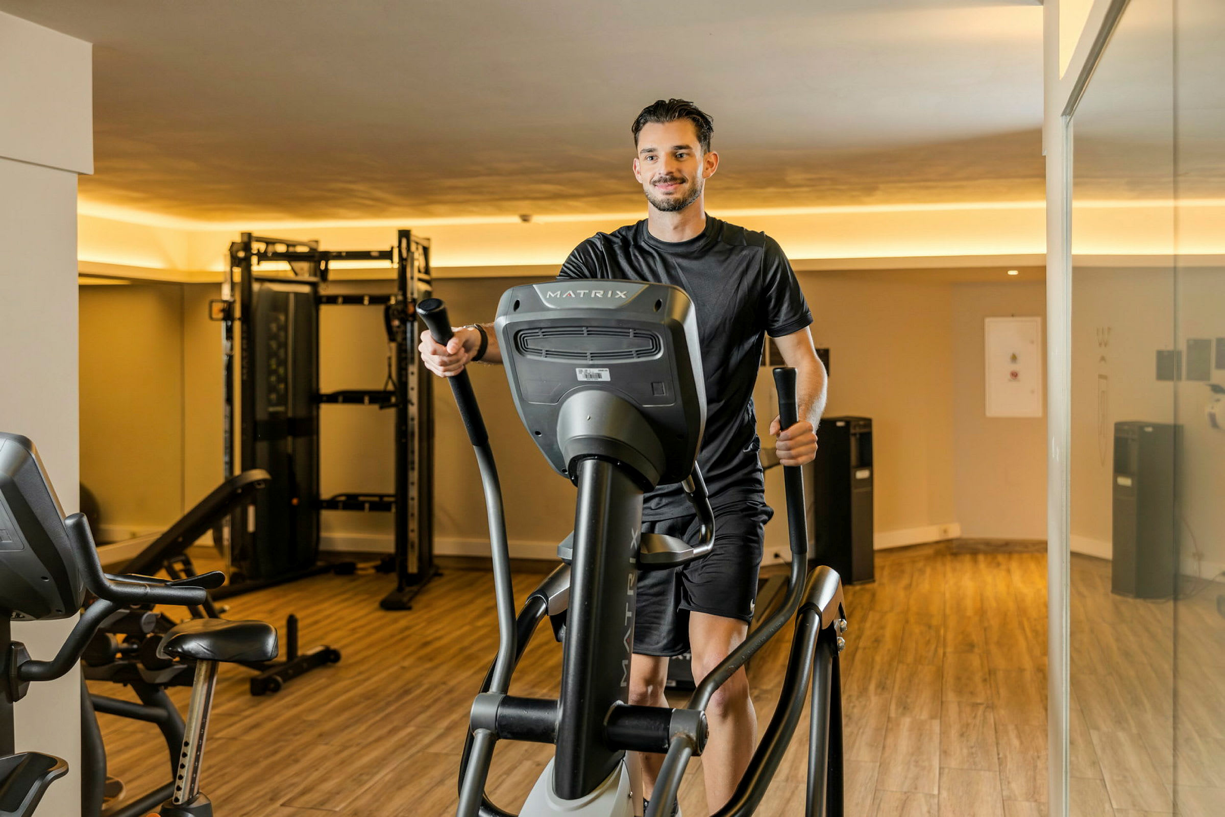 En person trener på en ellipsemaskin på et treningsstudio. (AI-generert tekst)