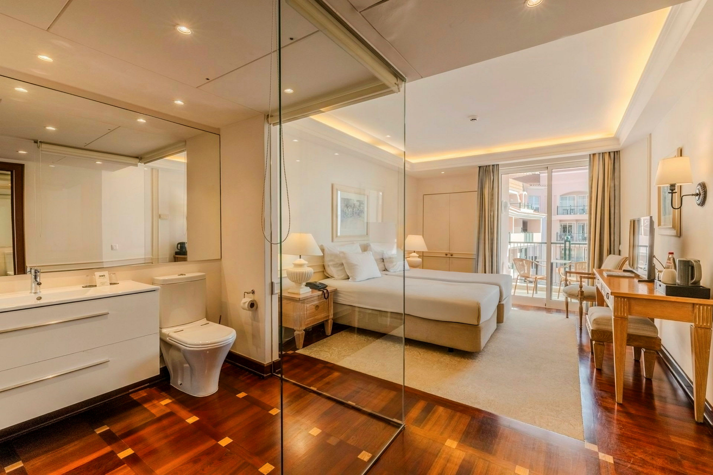 Et hotellrom med et stort soveområde, et skrivebord og en balkong med utsikt. Badet er delvis integrert med rommet og har moderne fasiliteter. (AI-generert tekst)
