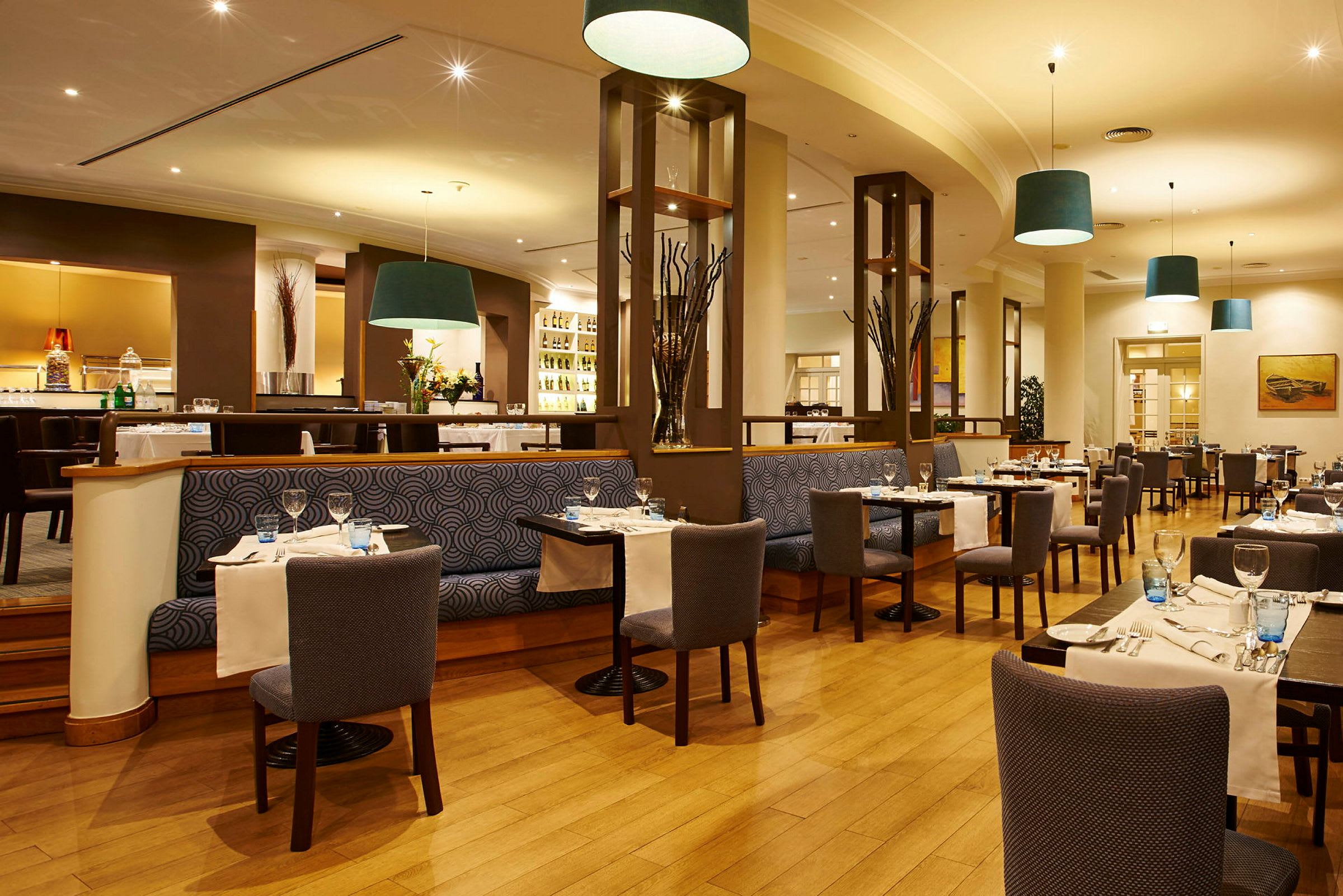 Bilde av en elegant restaurant med bord og stoler arrangert for gjester. (AI-generert tekst)