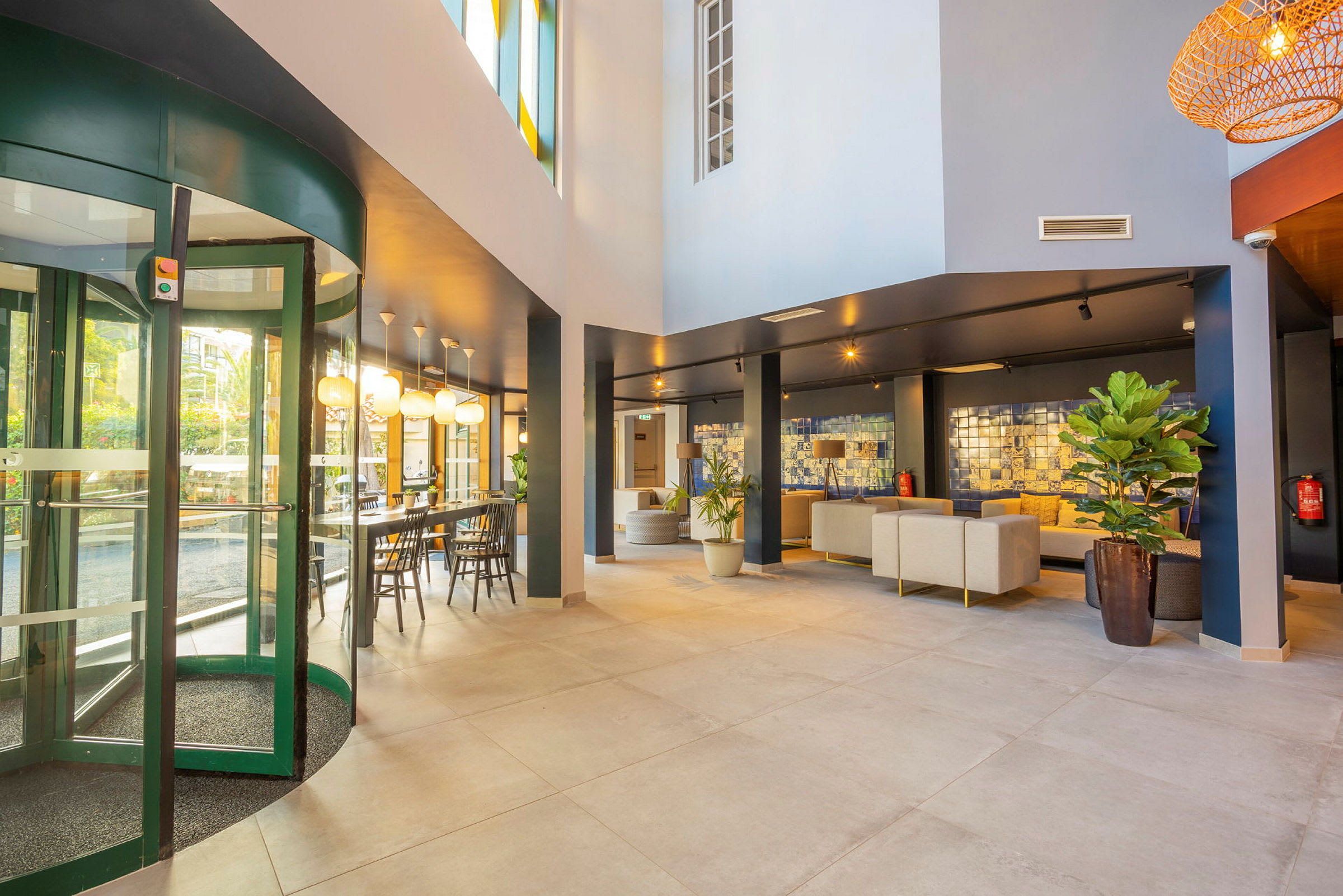 Hotellobby med komfortable sittemøbler og glassdører. (AI-generert tekst)