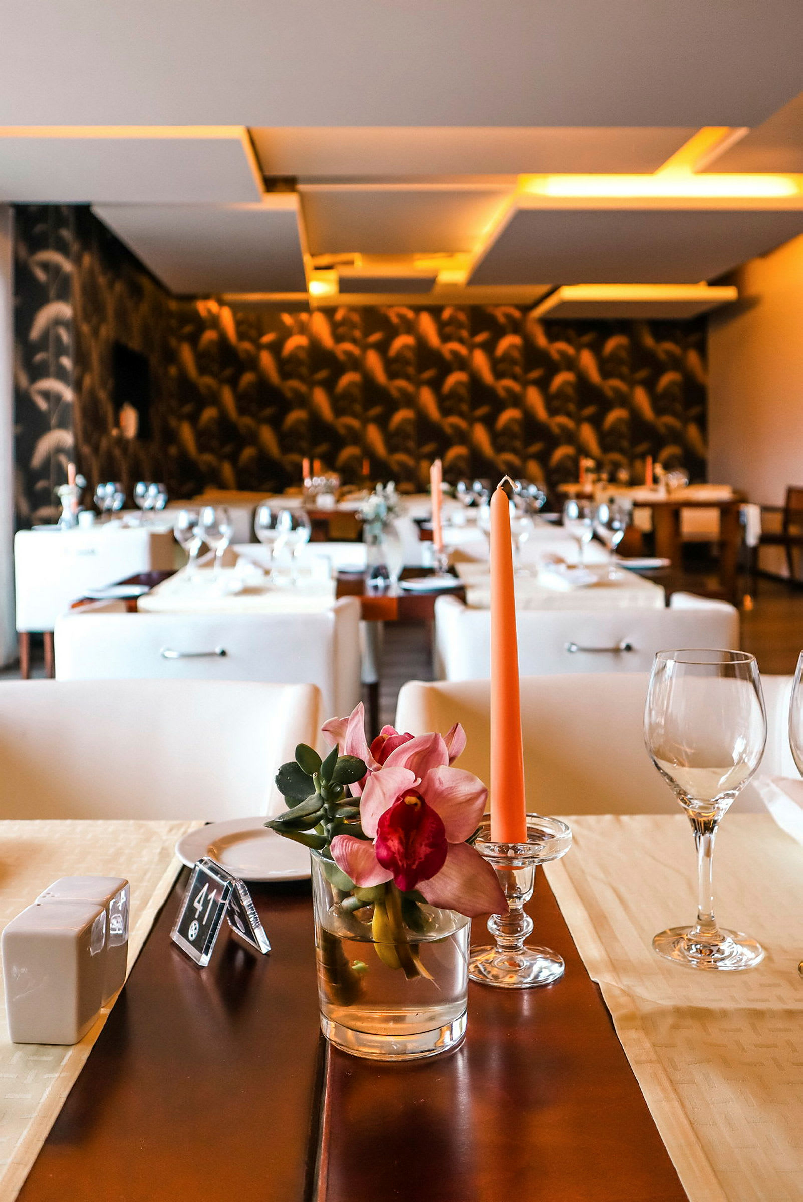En elegant restaurant med dekkede bord, dekorert med blomster og lys. (AI-generert tekst)