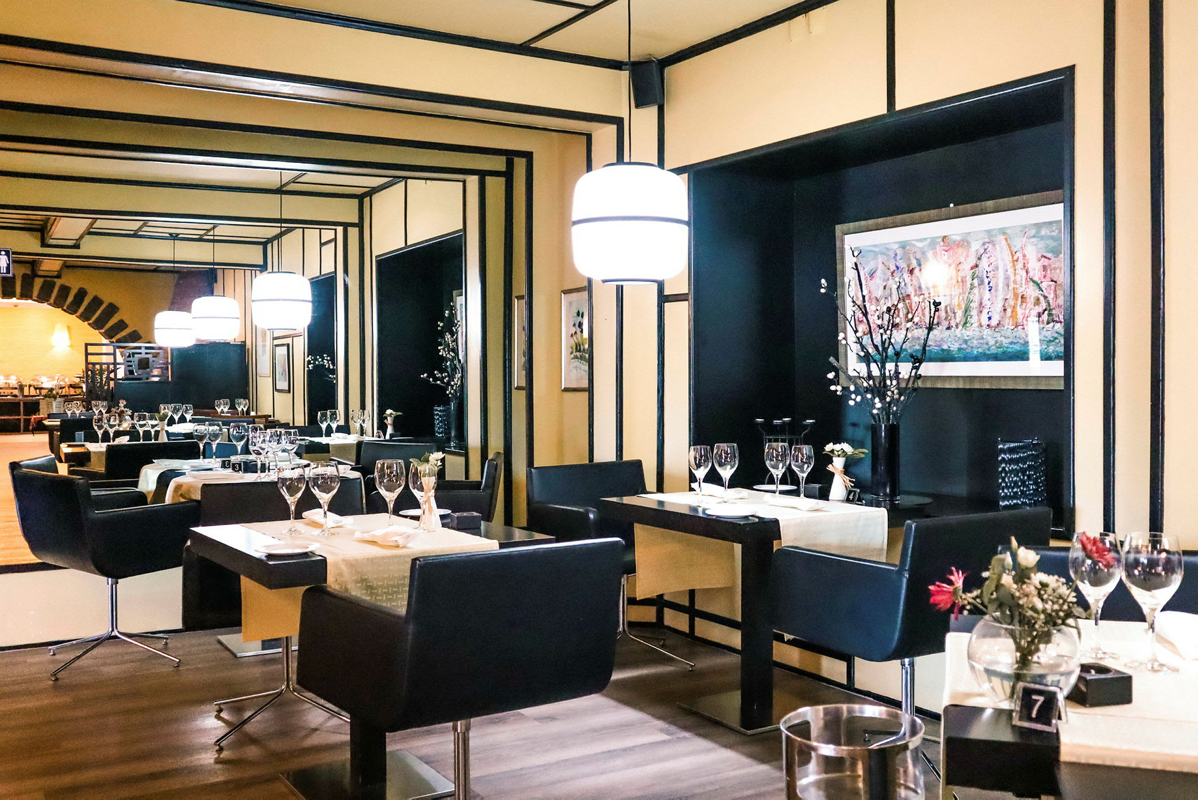En elegant restaurant med dekkede bord, stoler og moderne belysning. (AI-generert tekst)