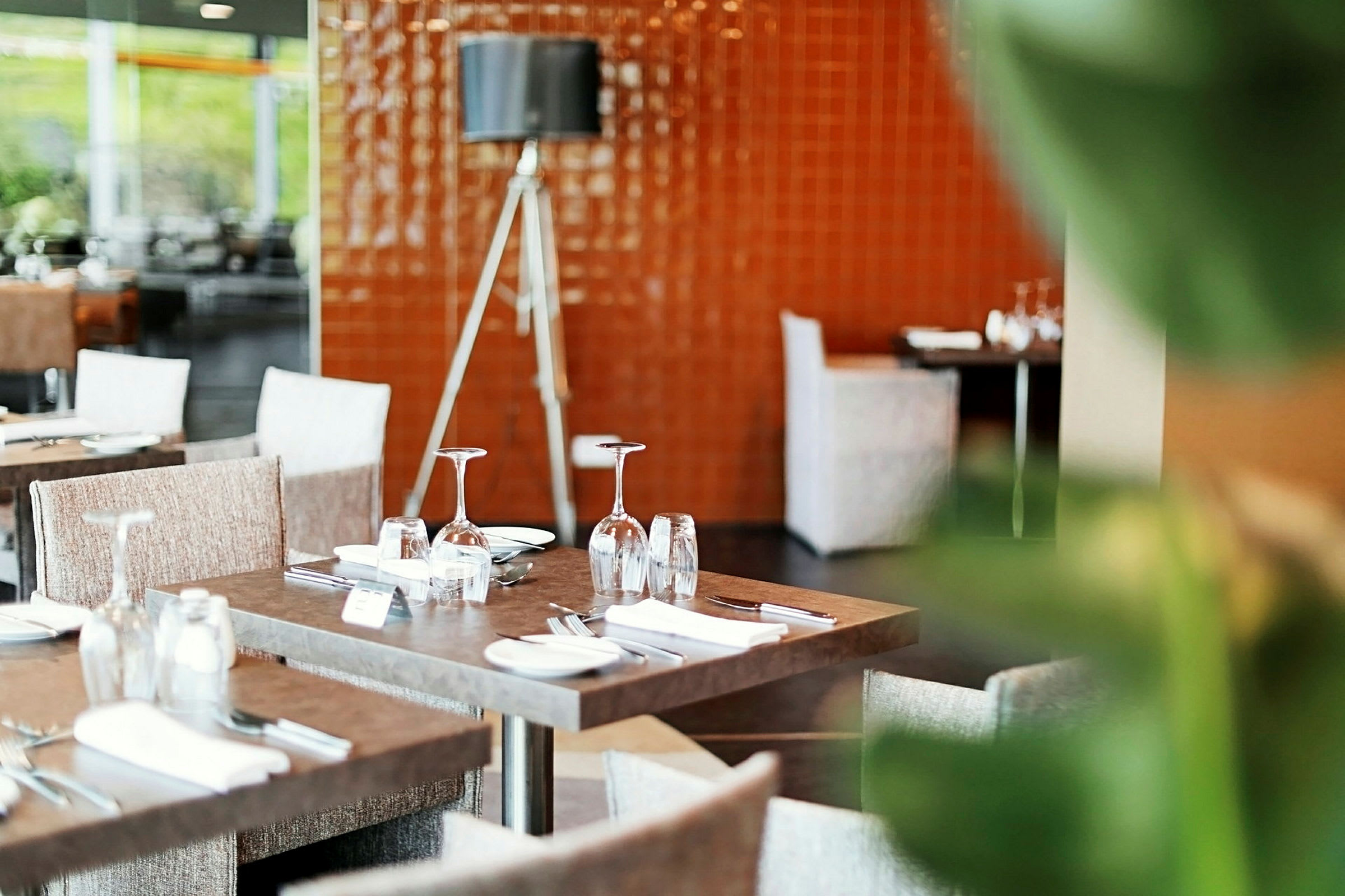 En restaurant med dekkede bord og sitteplasser. (AI-generert tekst)