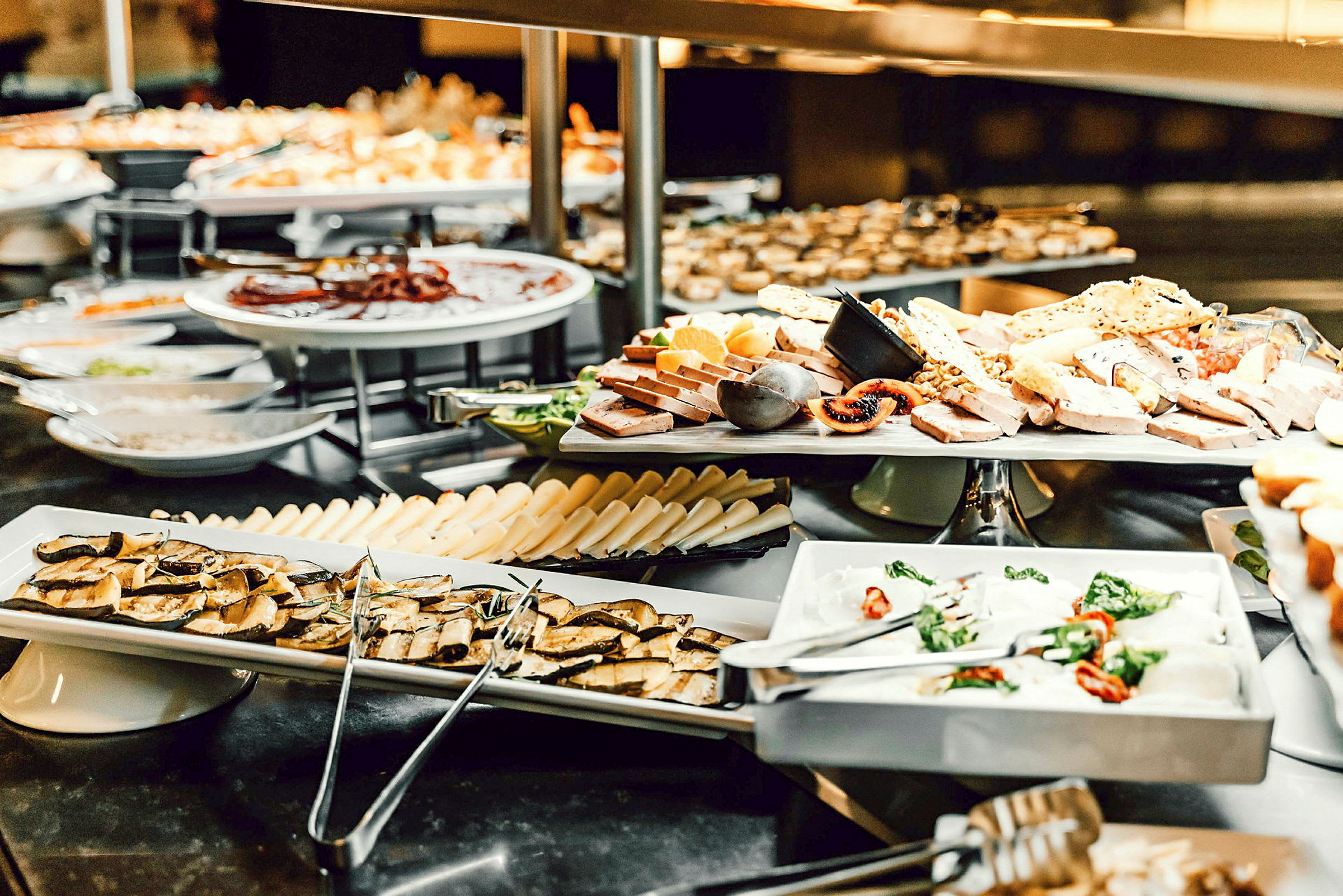 Bilde av en buffet med ost, frukt og andre matvarer anrettet på tallerkener. (AI-generert tekst)
