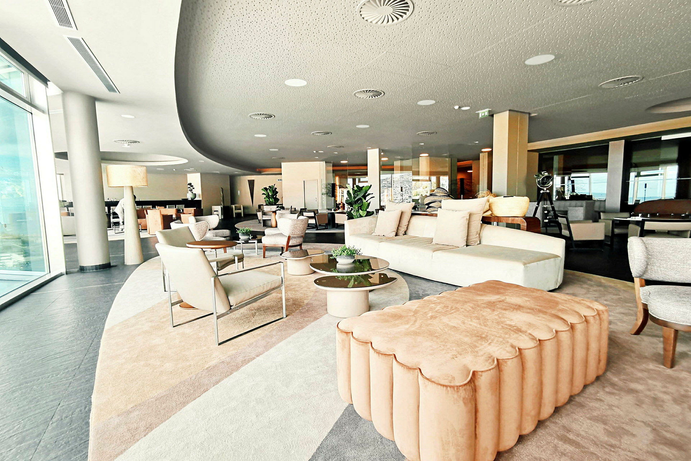 Et moderne innredet oppholdsrom med sofaer, lenestoler og bord med planter. (AI-generert tekst)