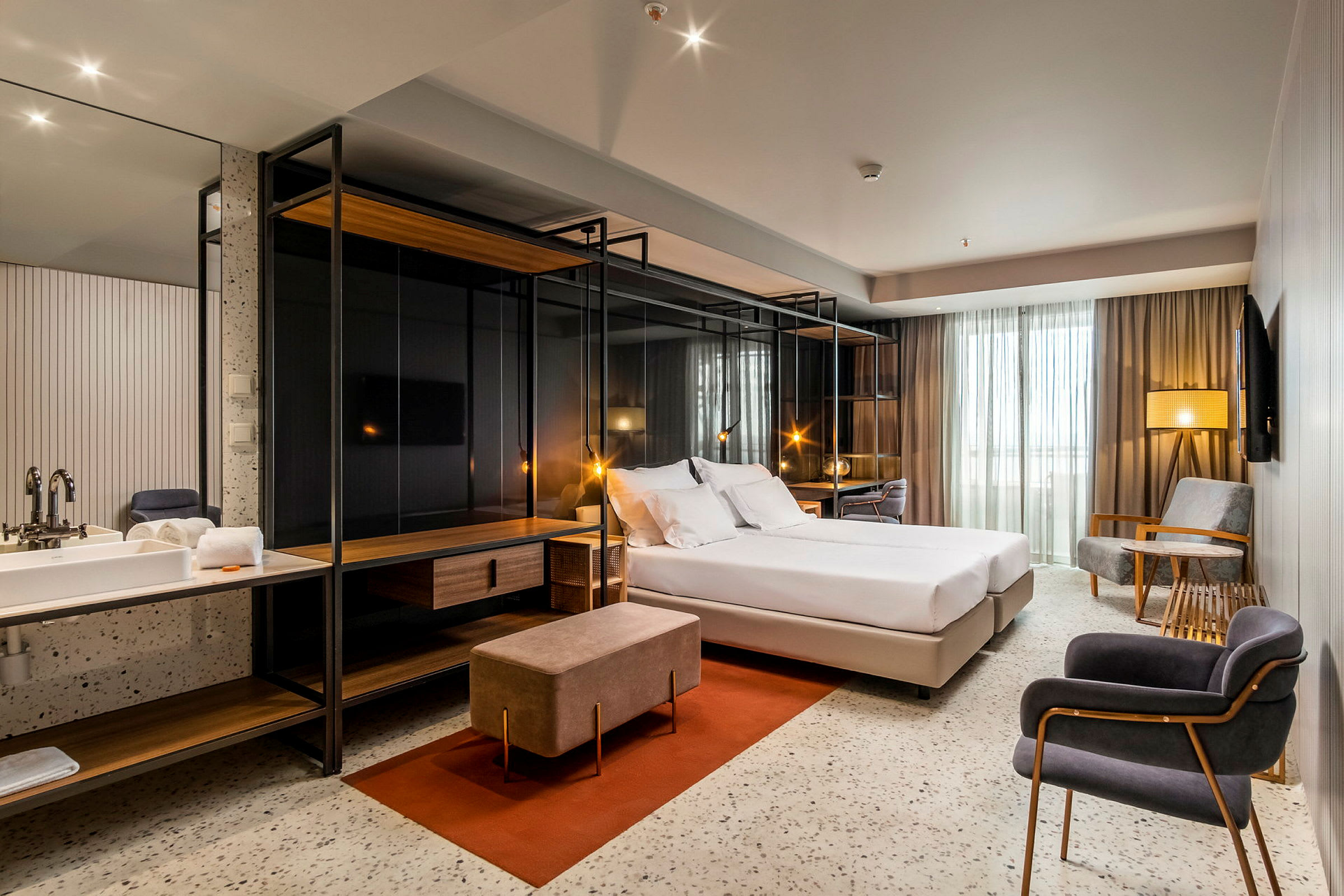 Moderne hotellrom med dobbeltseng, sittegruppe og skrivebord. (AI-generert tekst)