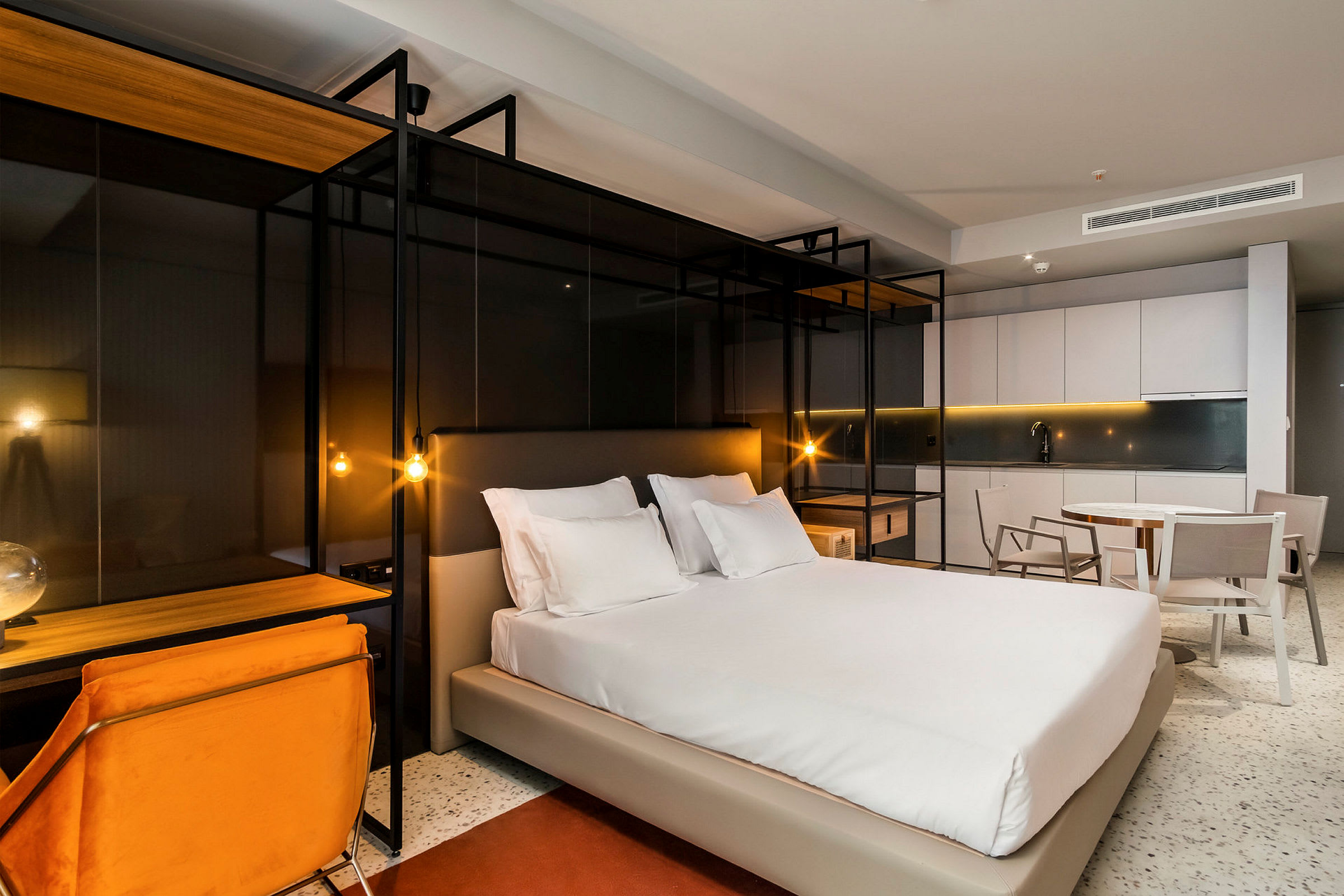 Moderne innredet hotellrom med en dobbeltseng, skrivebord og sittemøbler. (AI-generert tekst)