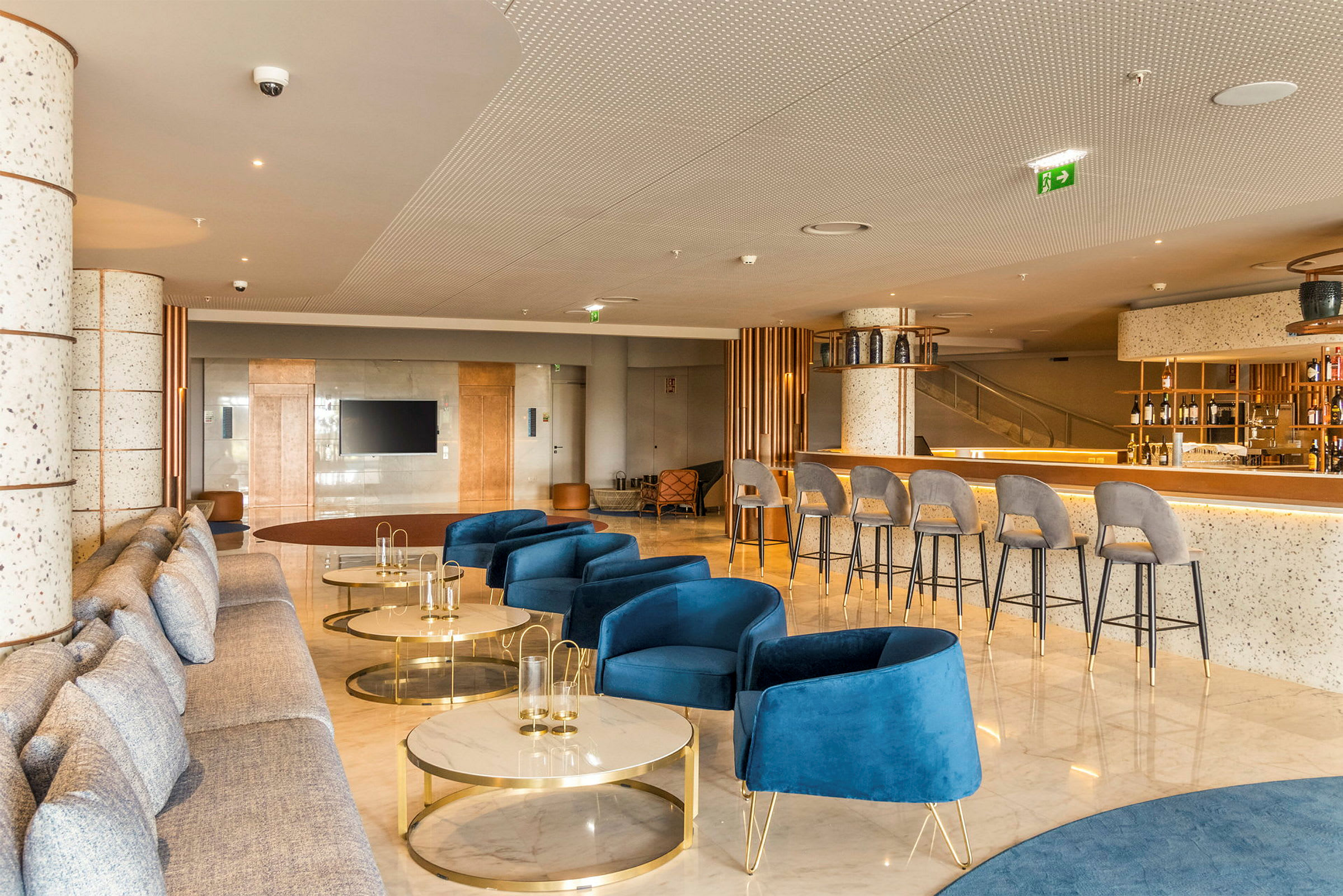 Moderne hotellrom med blå stoler, sofaer og et barområde. (AI-generert tekst)