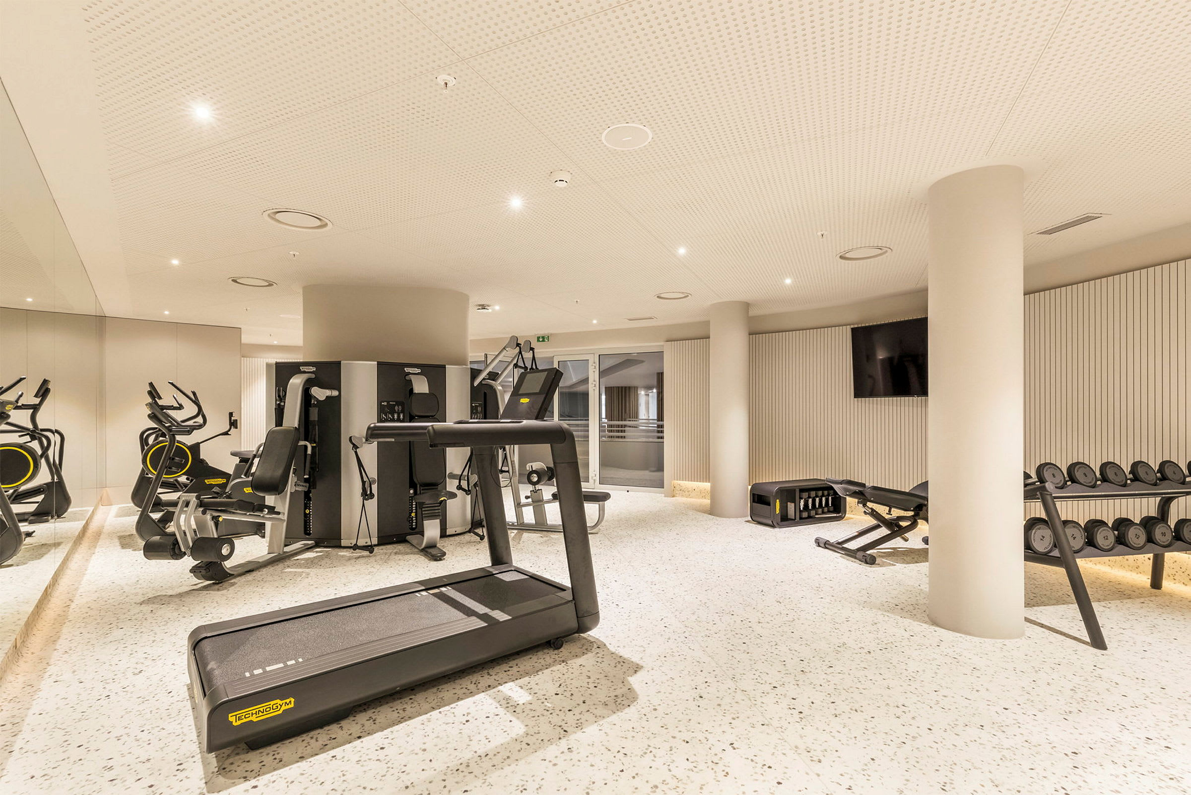 Et moderne treningsstudio med treningsmaskiner, tredemølle og vekter. (AI-generert tekst)