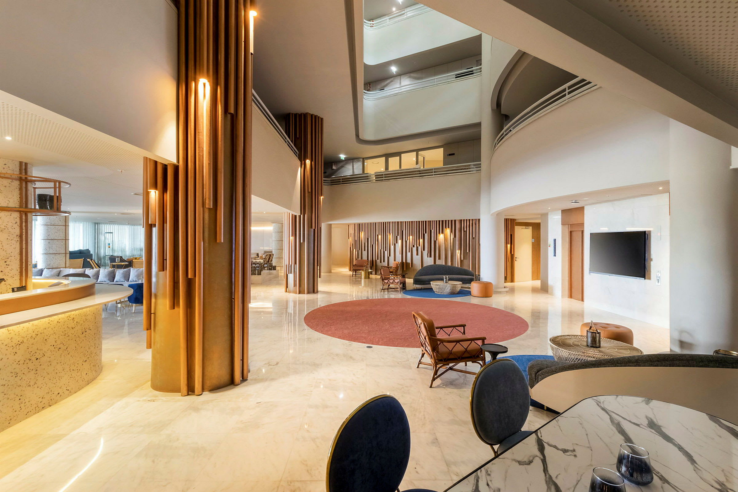 Lys og romslig hotellobby med moderne innredning, sittegrupper og store glassflater. (AI-generert tekst)