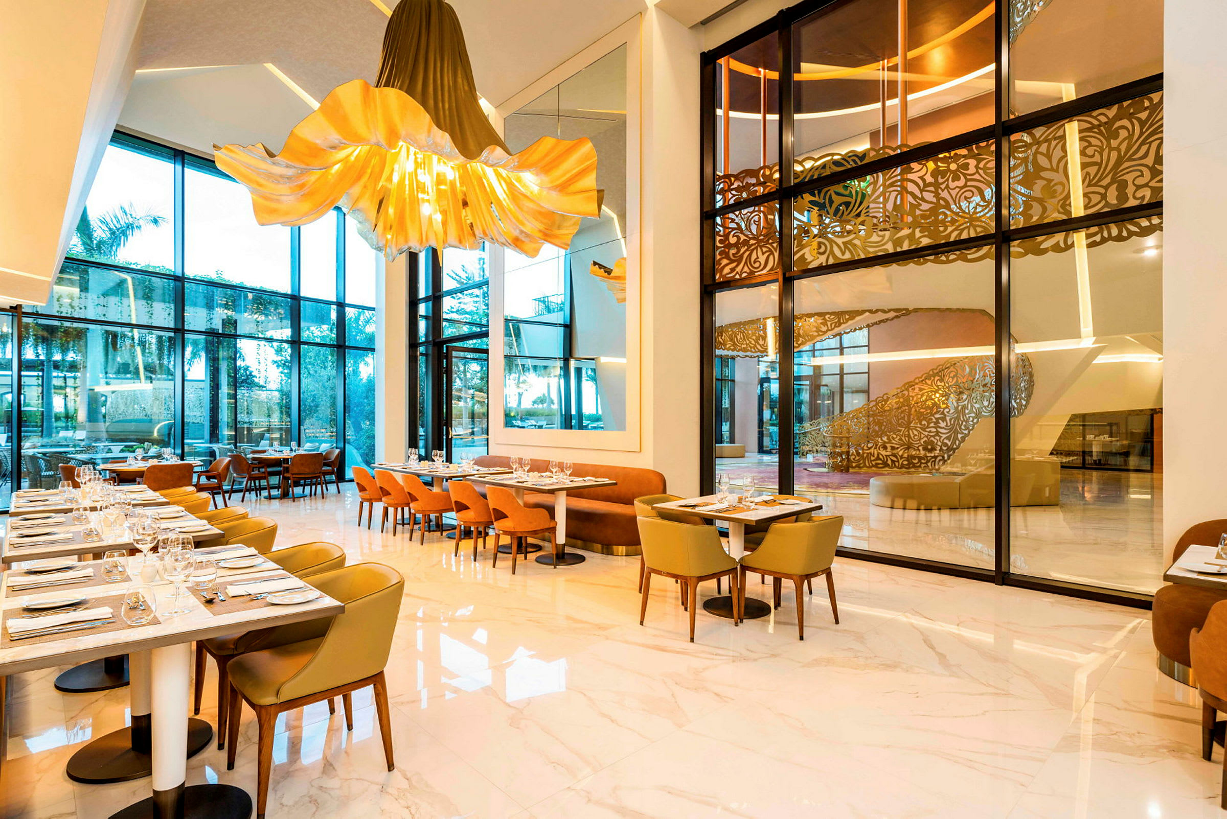 Moderne restaurant med store glassvinduer, elegante stoler og belysning. (AI-generert tekst)