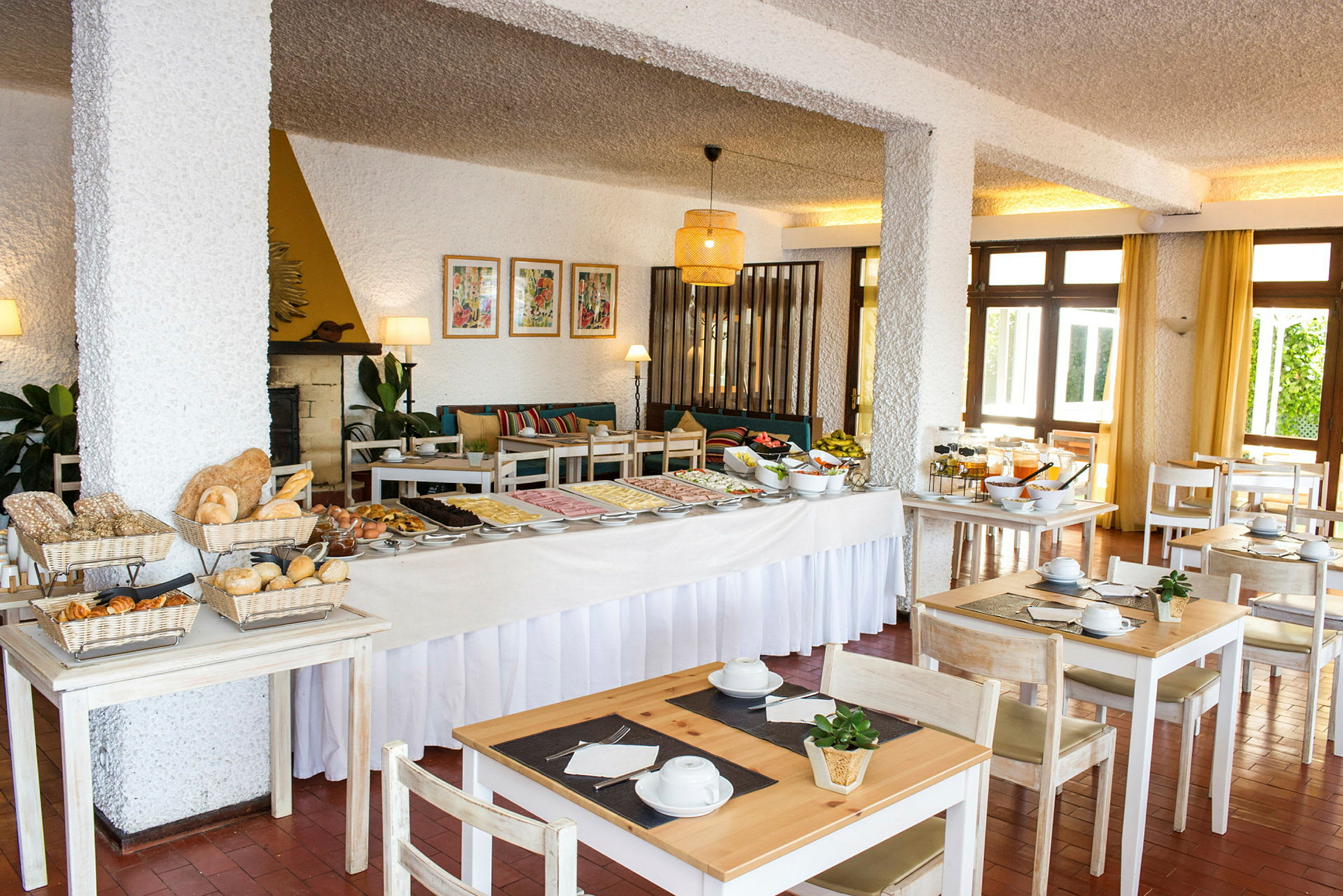 Et hotellrestaurantområde med en frokostbuffé og sitteplasser. (AI-generert tekst)