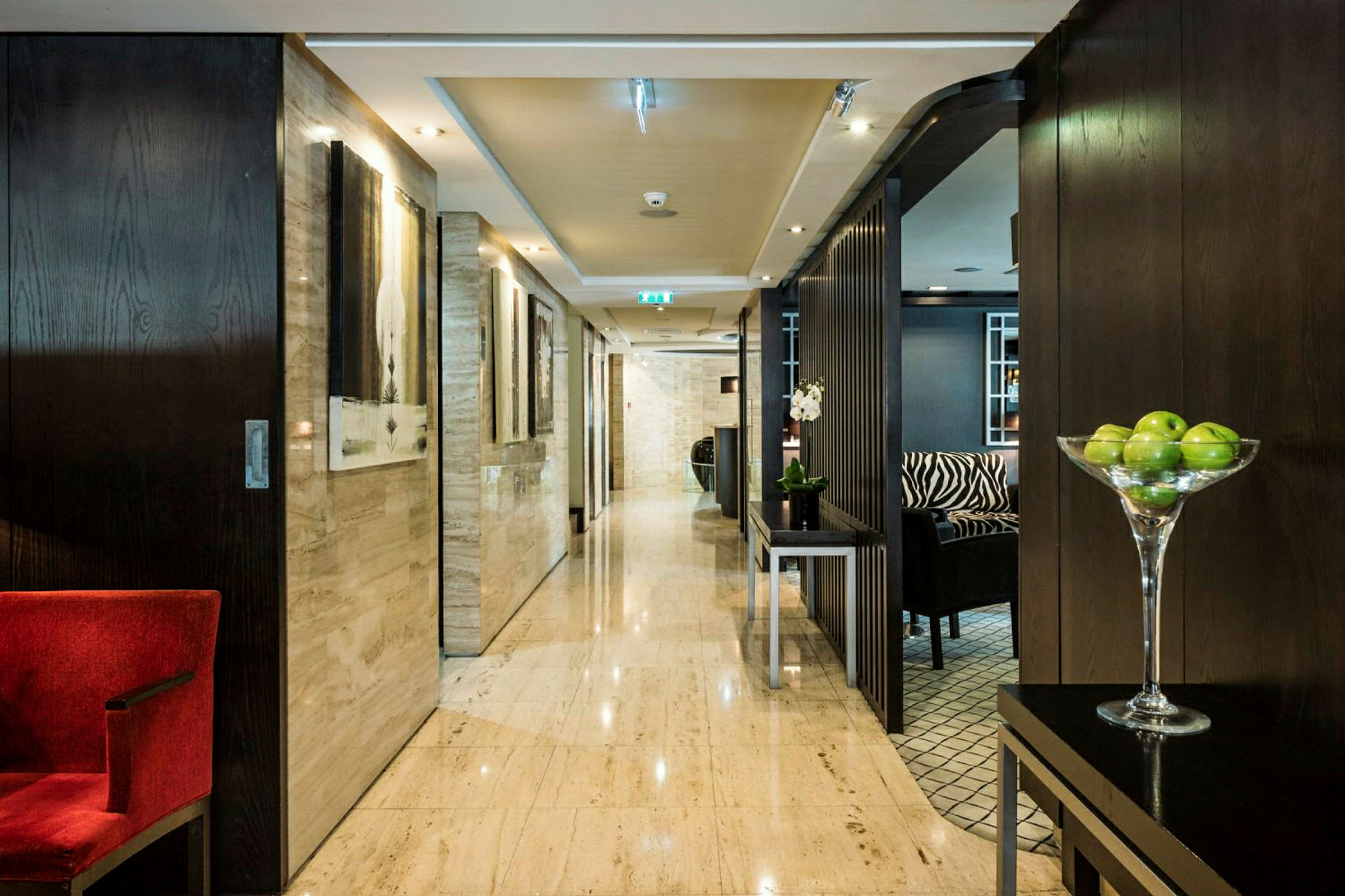 Hotellkorridor med moderne innredning og grønne epler i en bolle. (AI-generert tekst)