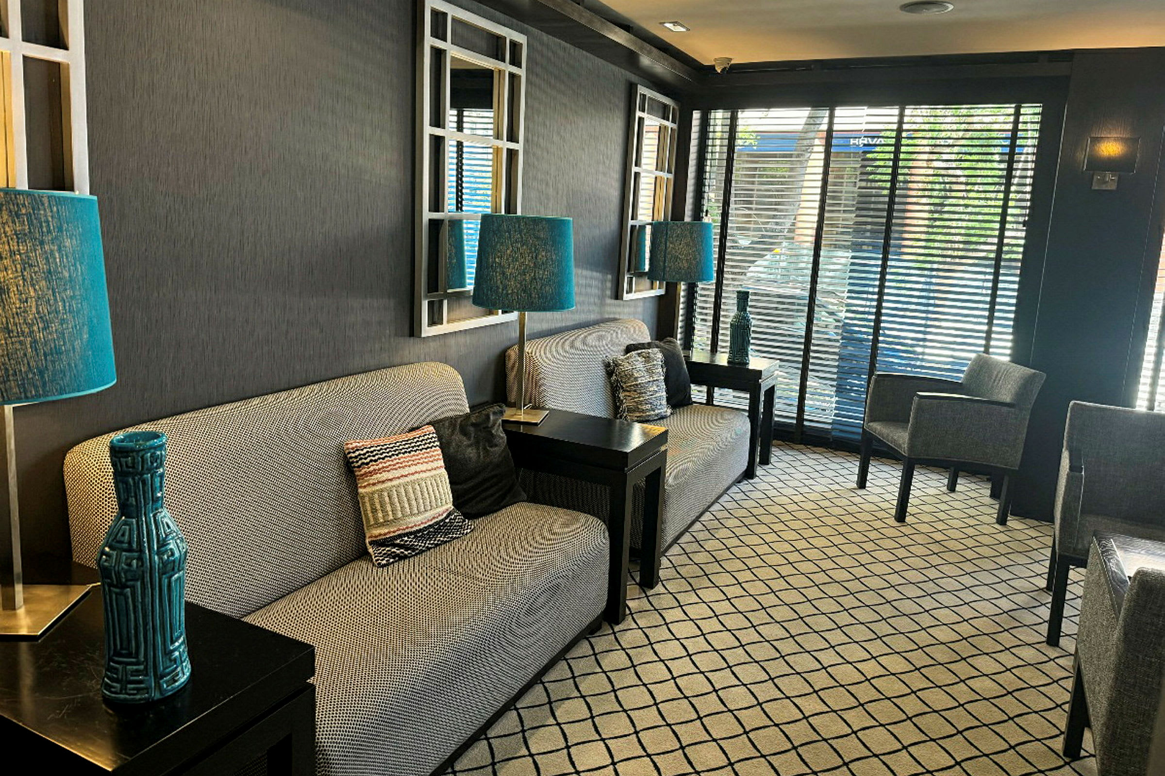 En hotellobby med sofaer, blå lamper og moderne detaljer. (AI-generert tekst)