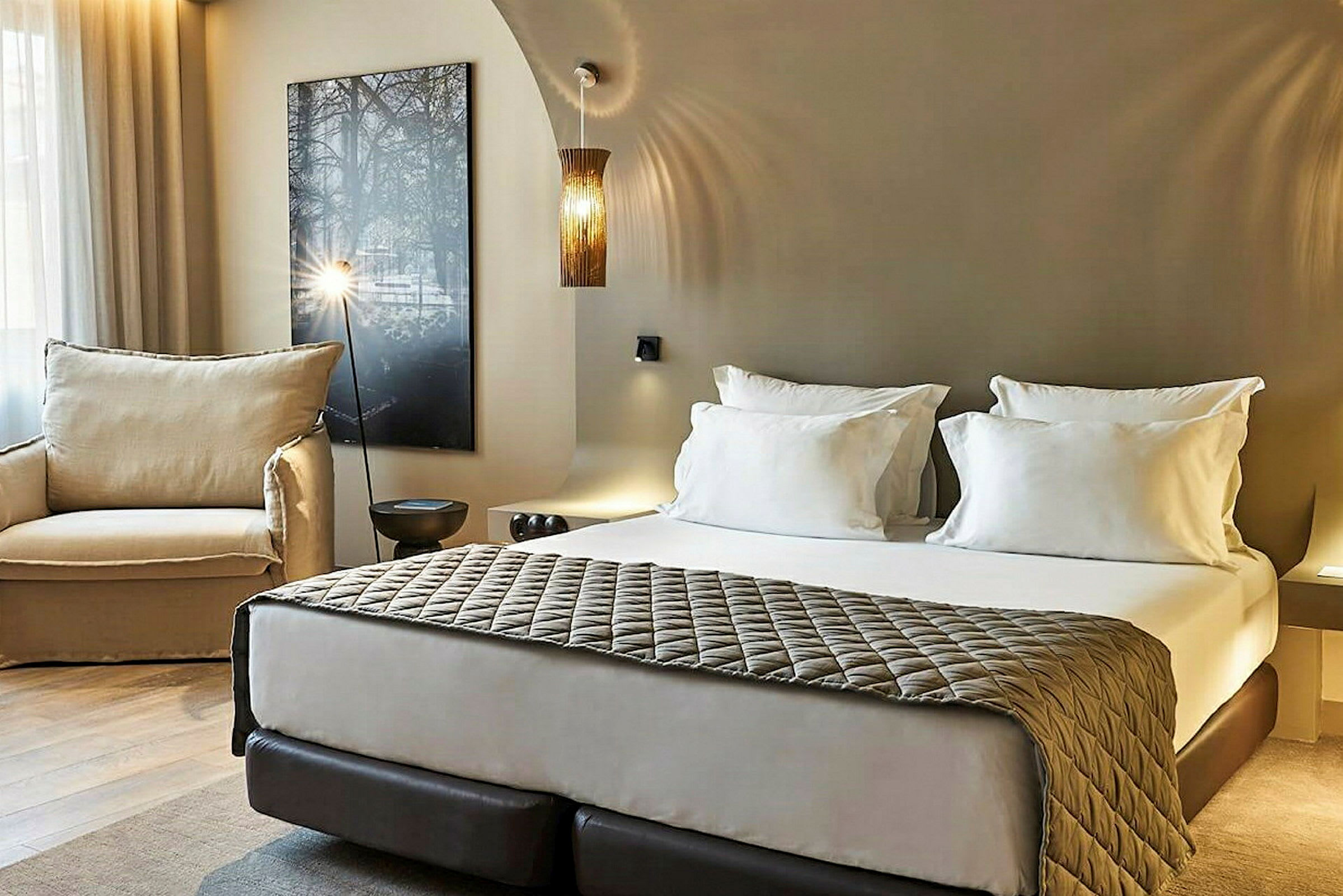 Moderne hotellrom med dobbeltseng, lenestol og avslappende innredning. (AI-generert tekst)