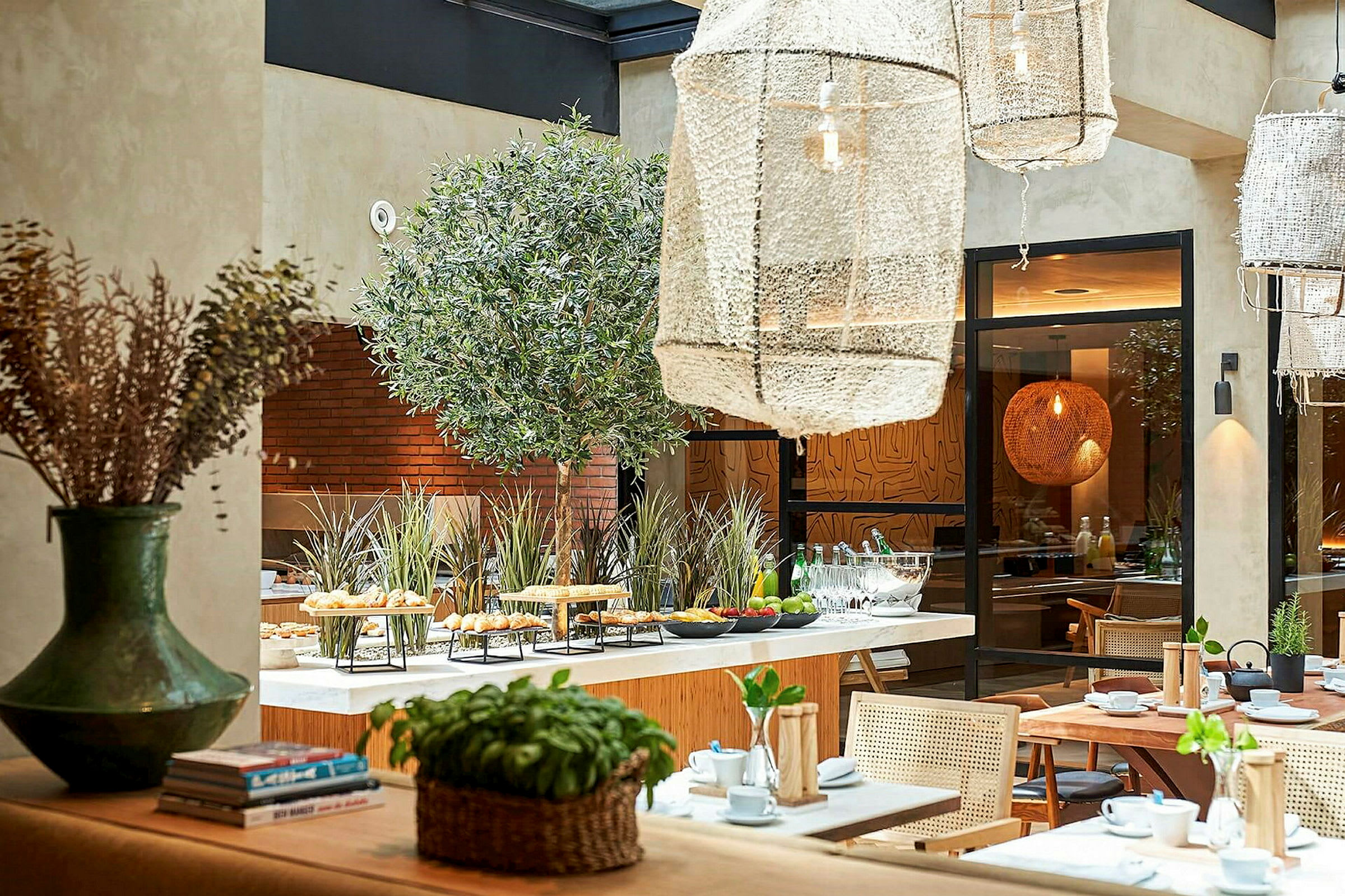 Et lyst restaurantinteriør med bord, stoler og planteinnslag. (AI-generert tekst)