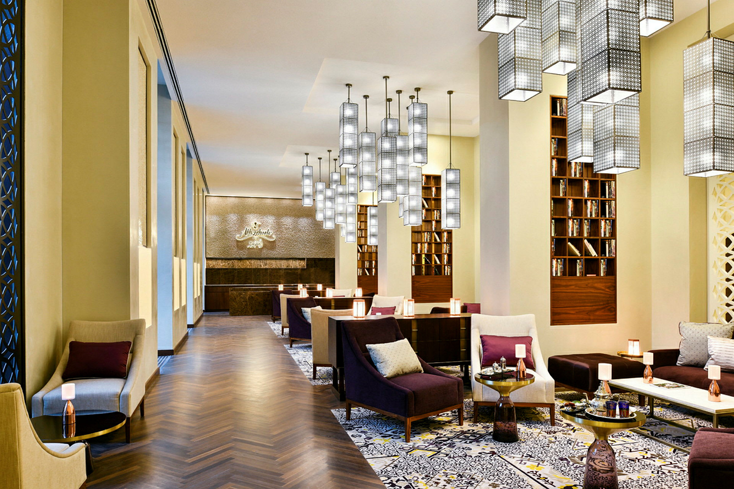 Interiør av en elegant hotellsalong med sitteplasser, bøker og moderne belysning. (AI-generert tekst)