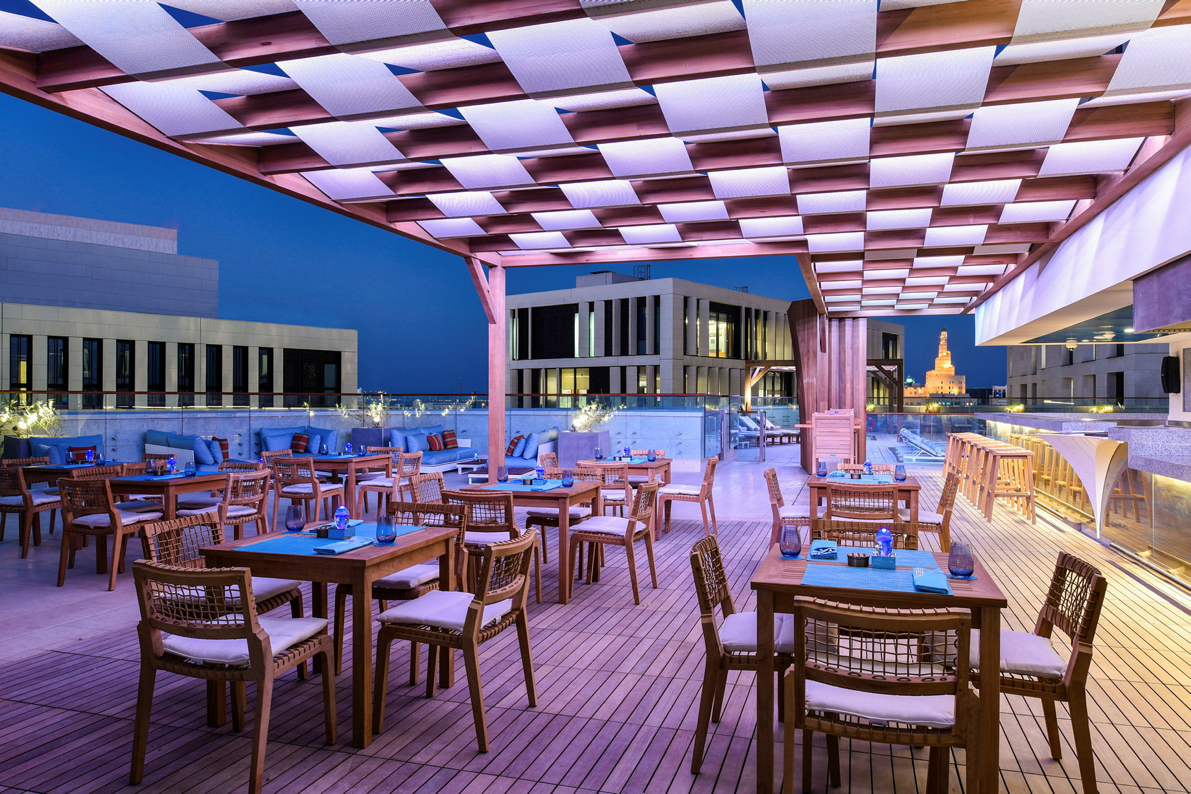 Takterrasse med sitteplasser og bord, med utsikt over byens arkitektur. (AI-generert tekst)