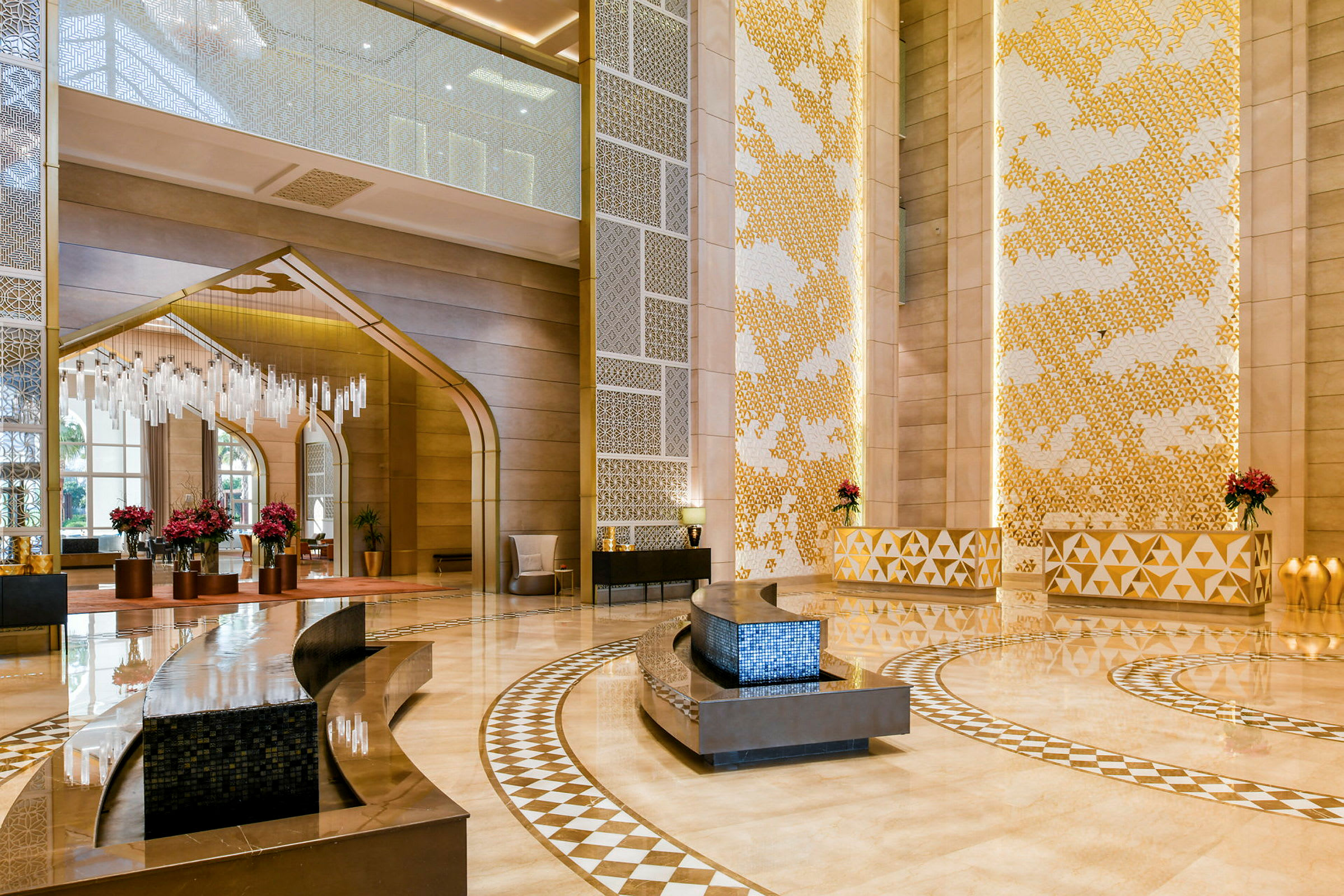 En elegant innredet hotellobby med høyt tak, dekorativt mønstret gulv og moderne møbler. (AI-generert tekst)