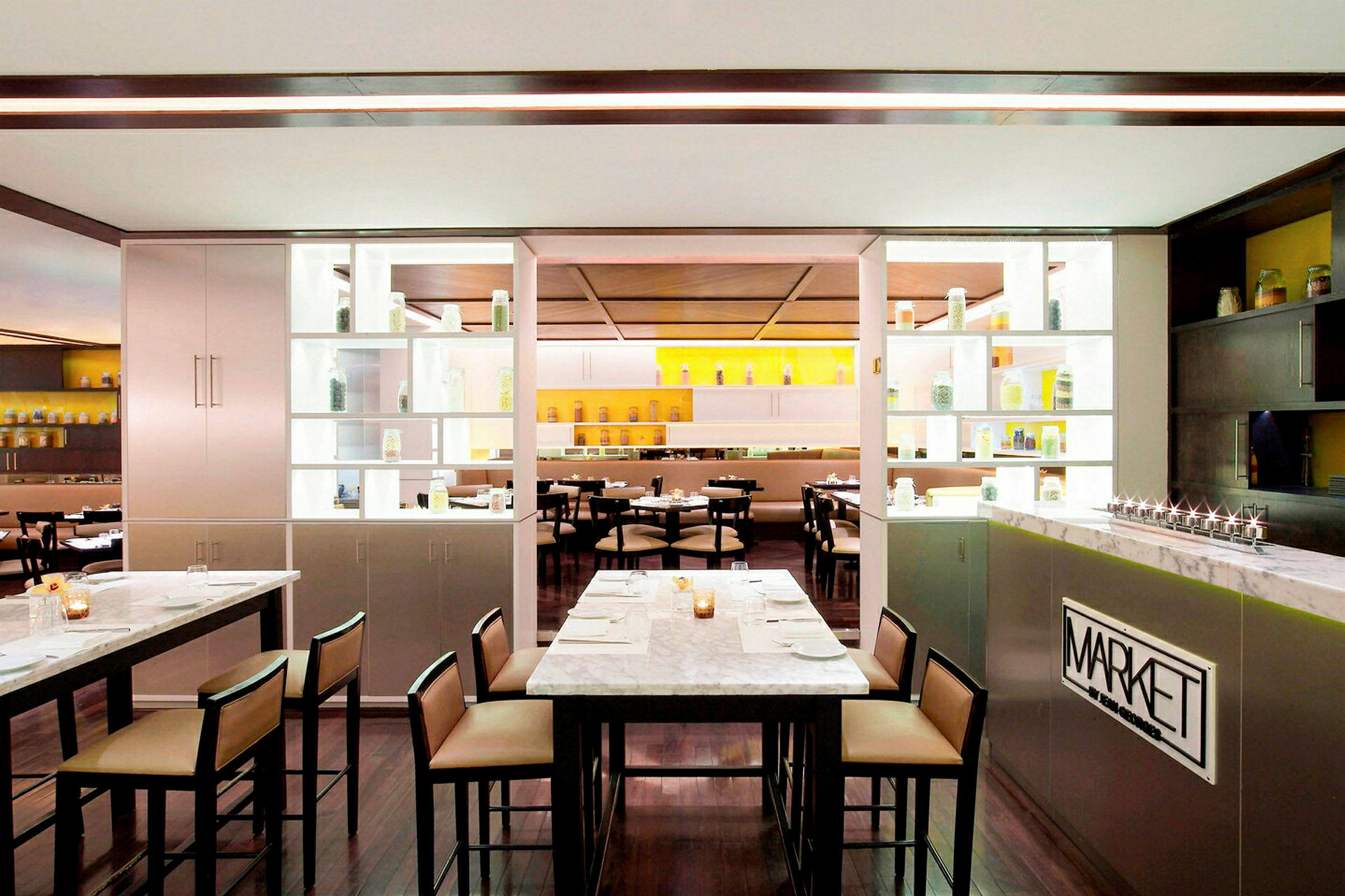 Et moderne restaurantinteriør med marmorbord og hyller med glasskrukker. (AI-generert tekst)
