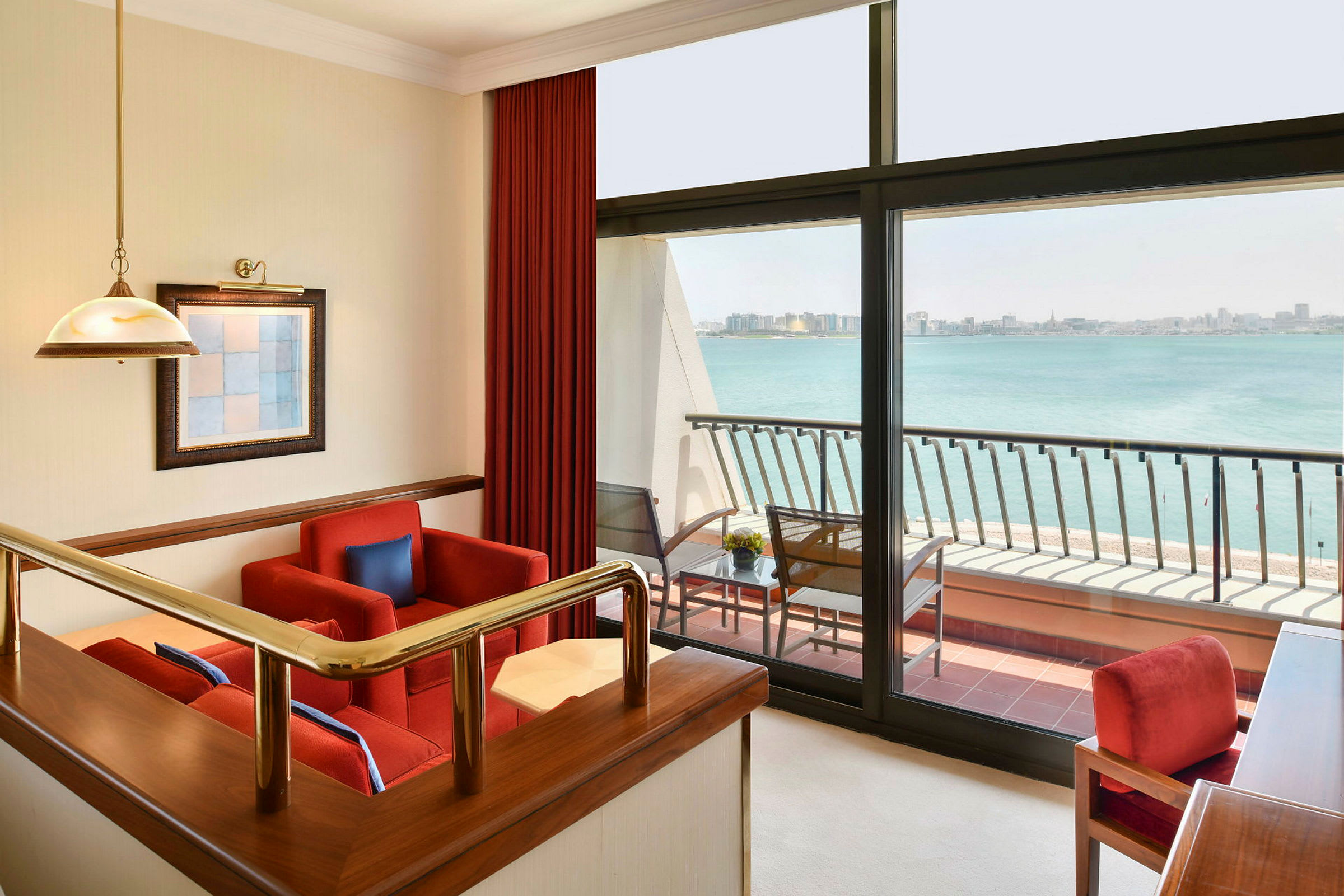 En moderne hotellsuite med sittegruppe, store vinduer og utsikt over havet. (AI-generert tekst)