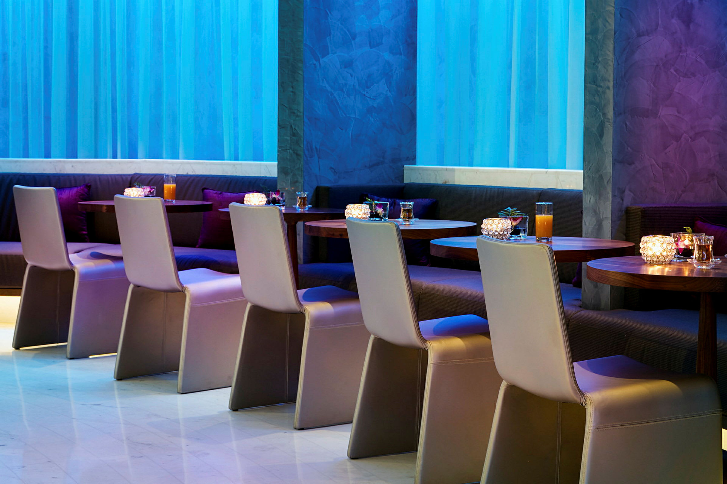 Restaurant med bord og stoler oppstilt i et moderne innemiljø. (AI-generert tekst)