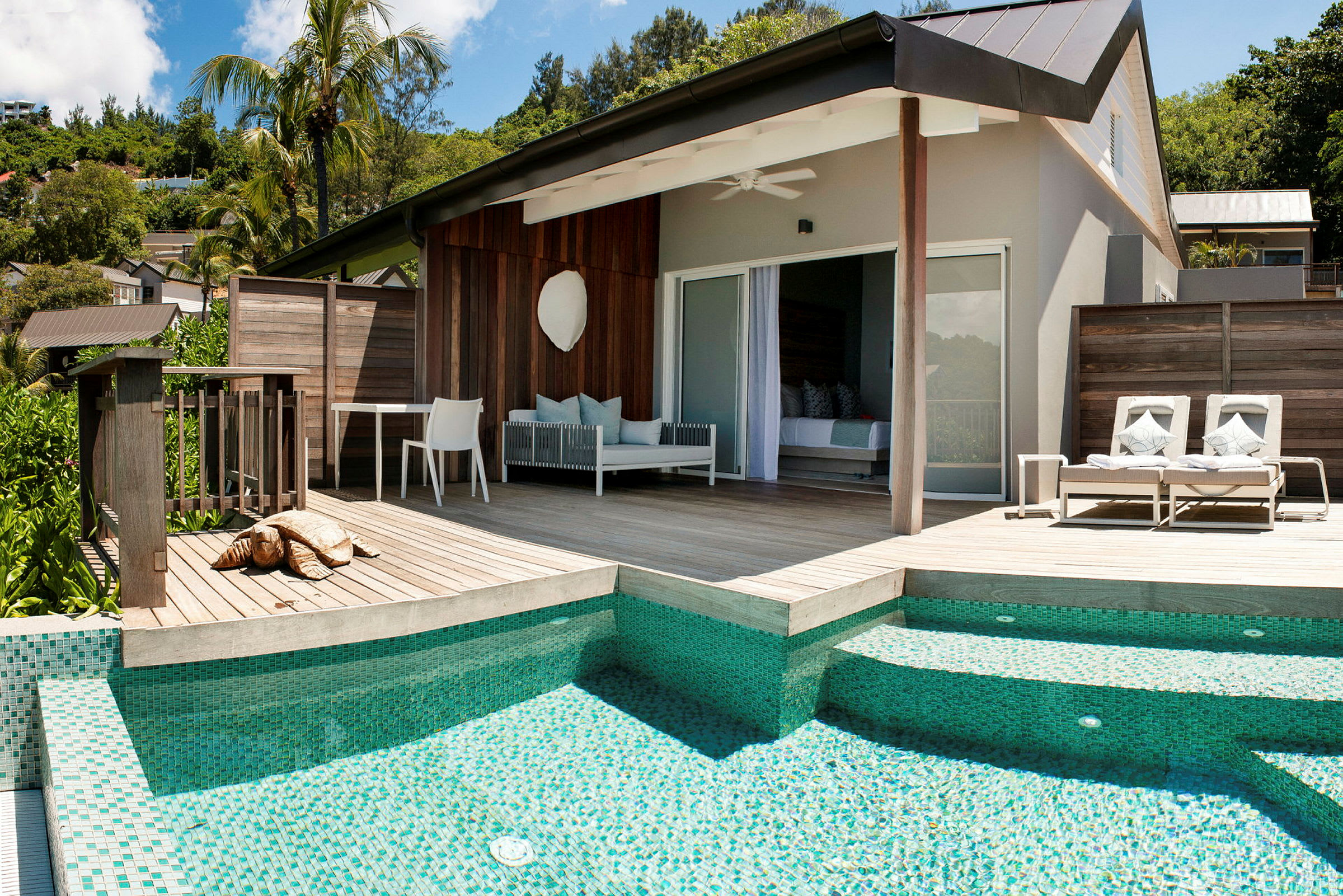 Moderne bungalow med treterrasse, solsenger og basseng. (AI-generert tekst)