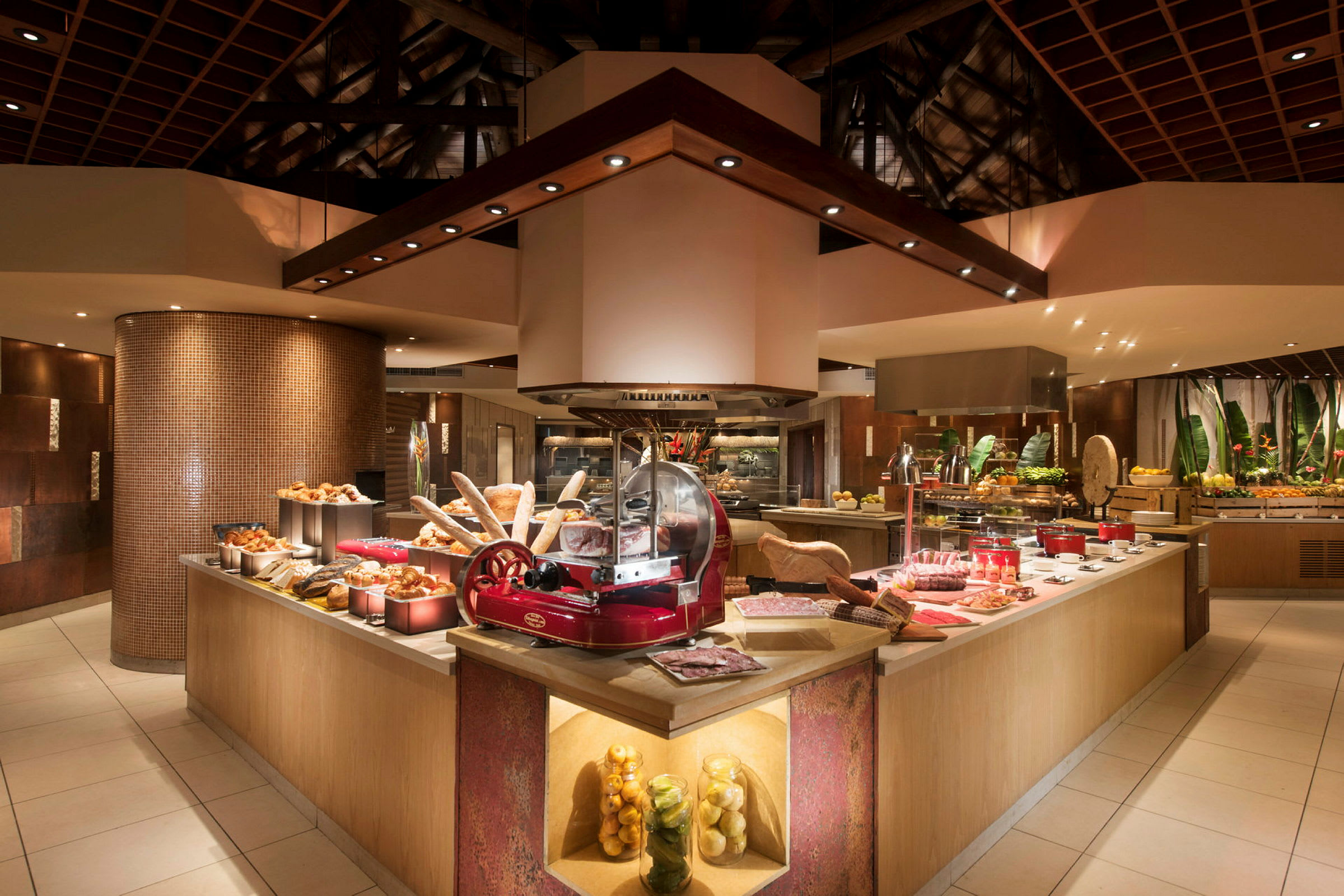Bilde av en godt opplyst buffet med ulike typer mat som brød og frukt samt skjæremaskin i sentrum. (AI-generert tekst)