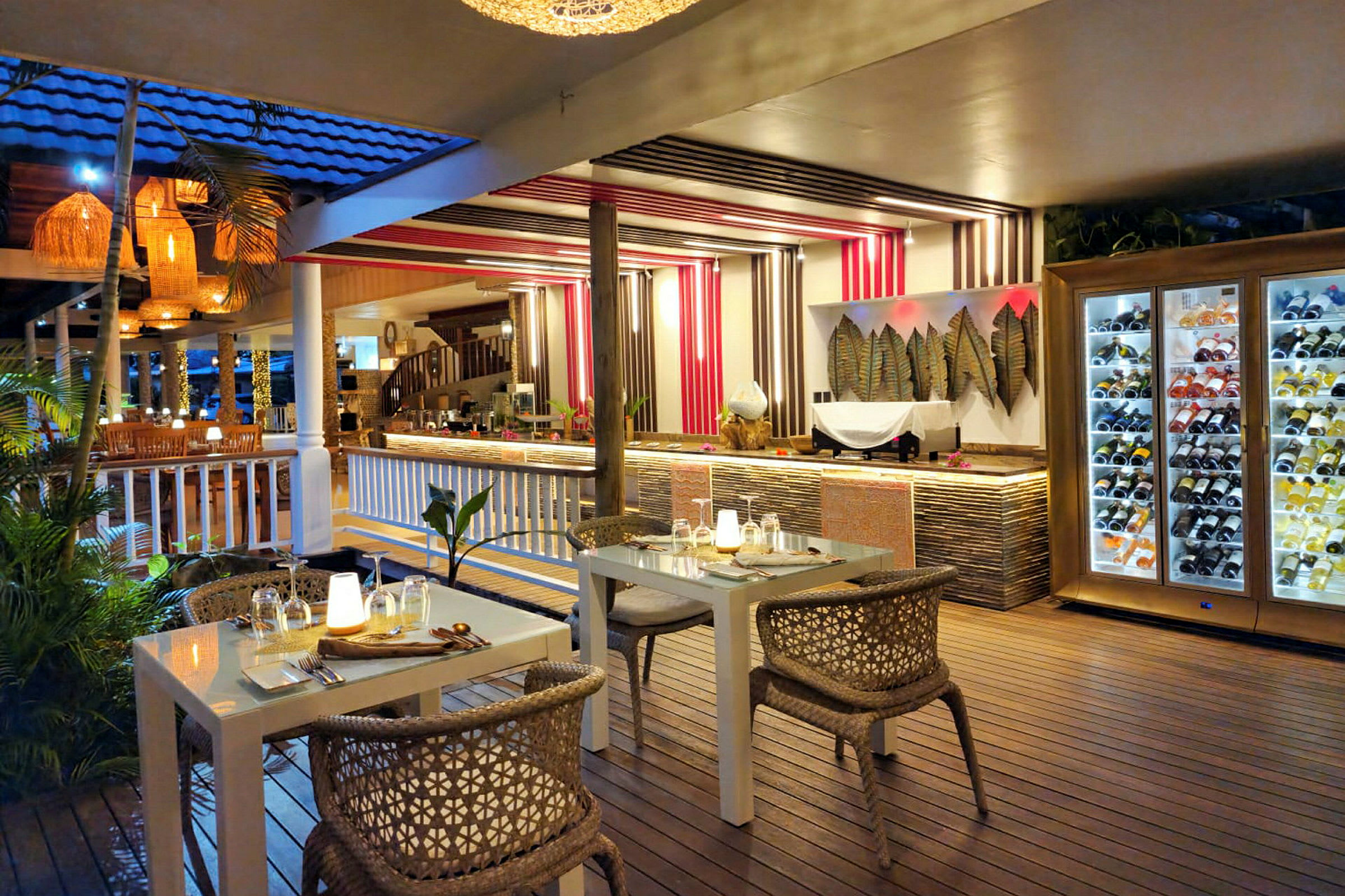 En restaurant med moderne møbler og dekor, inkludert et bord med dempet belysning og en vinlagringsenhet. (AI-generert tekst)