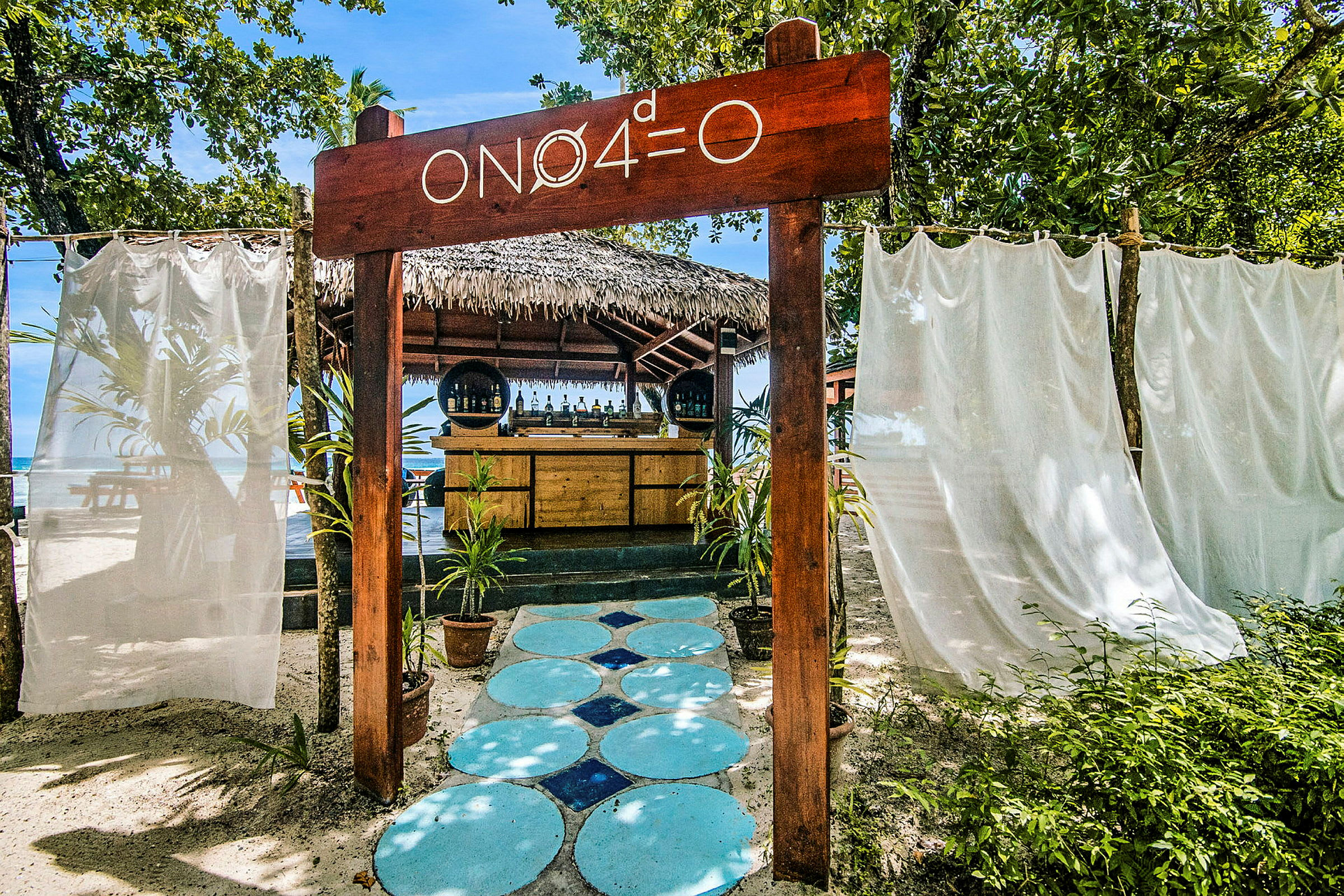 Strandbar med skilt og omkringliggende vegetasjon. (AI-generert tekst)