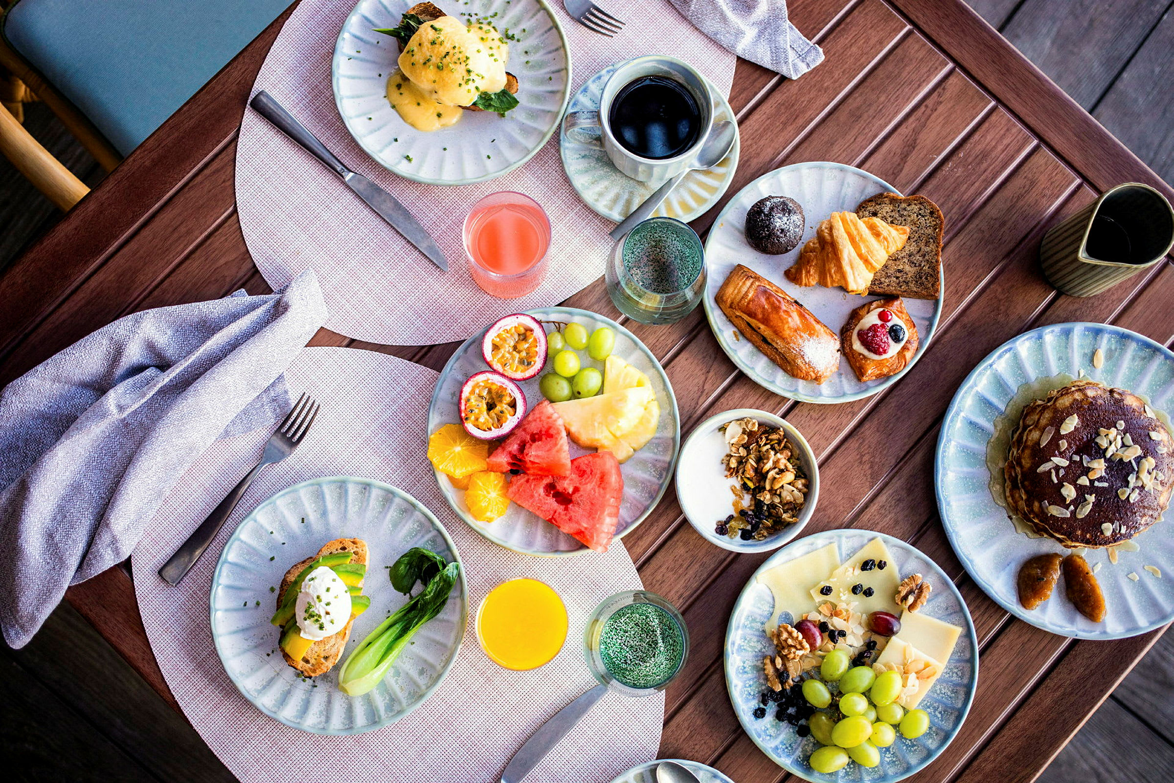Et bord med fargerik frokostmat, inkludert frukt, bakverk og drikke. (AI-generert tekst)