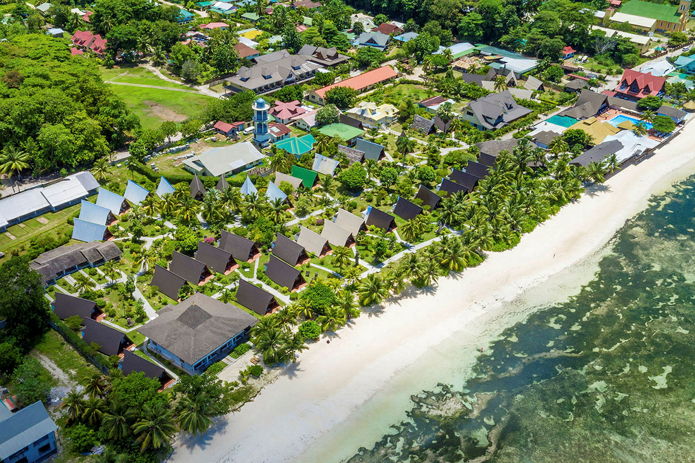 Flyfoto av en ferieresort ved stranden. (AI-generert tekst)