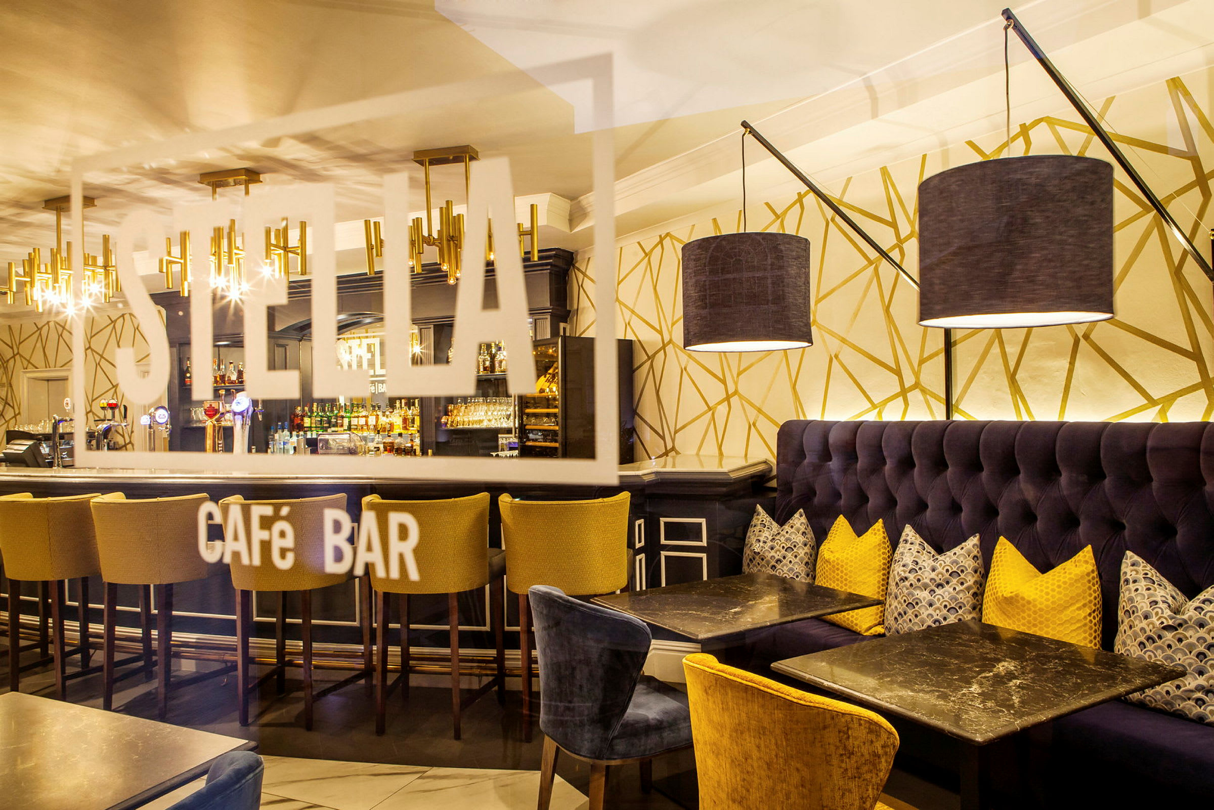 Interiør av en stilfull kafébar med sofaer, bord og en bardisk. (AI-generert tekst)