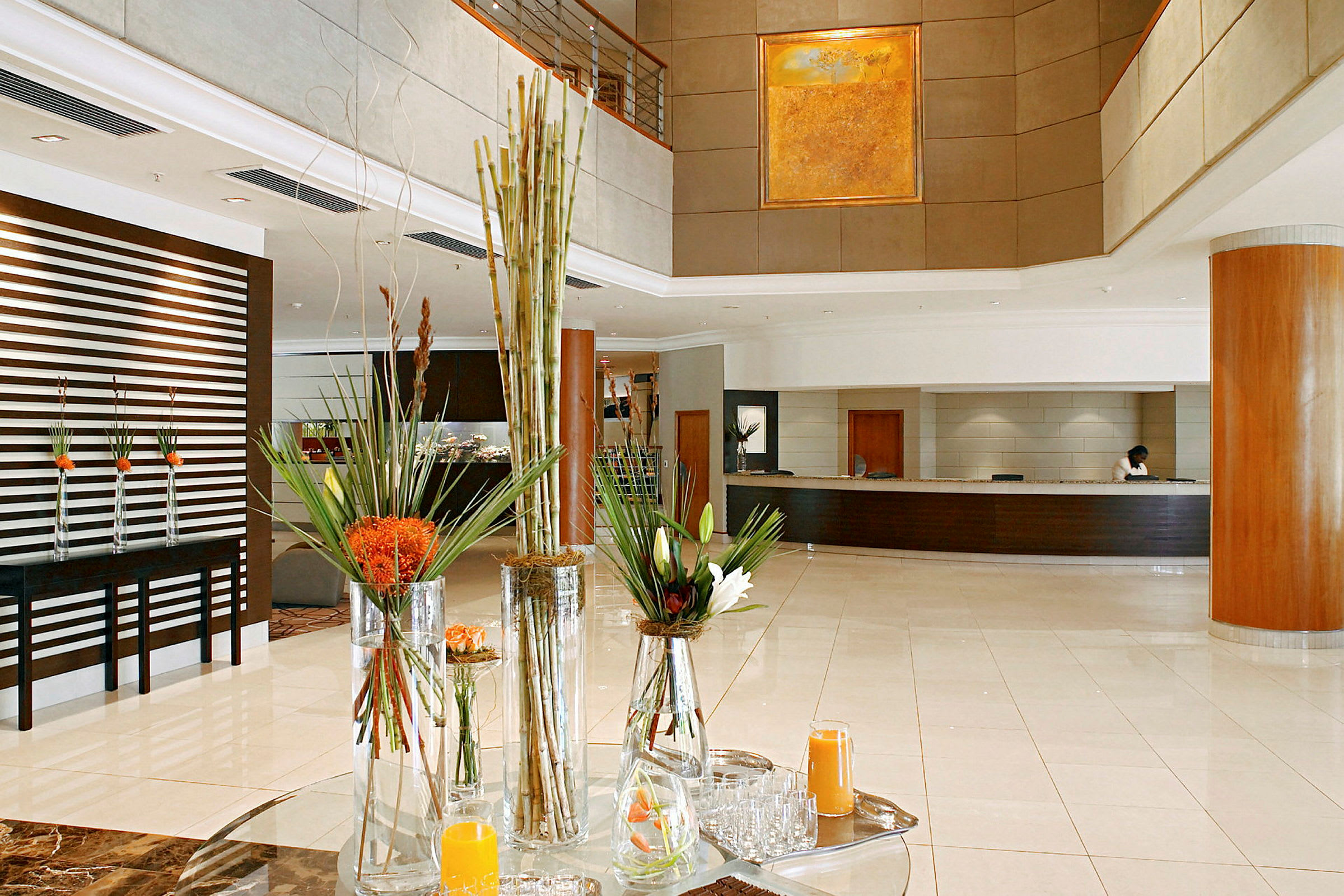 Lys og stilren hotellobby med resepsjon og blomsterarrangement. (AI-generert tekst)