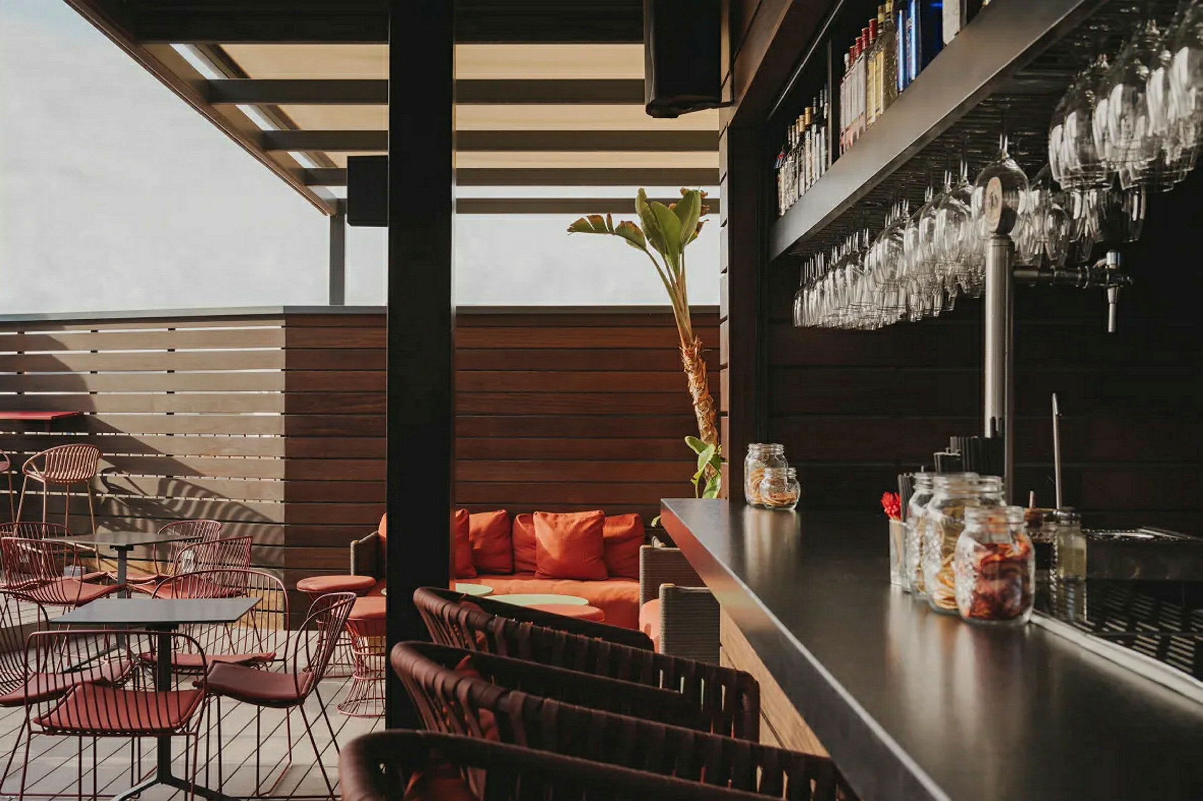 En moderne bar med sitteplasser og glass hengende på veggen. (AI-generert tekst)