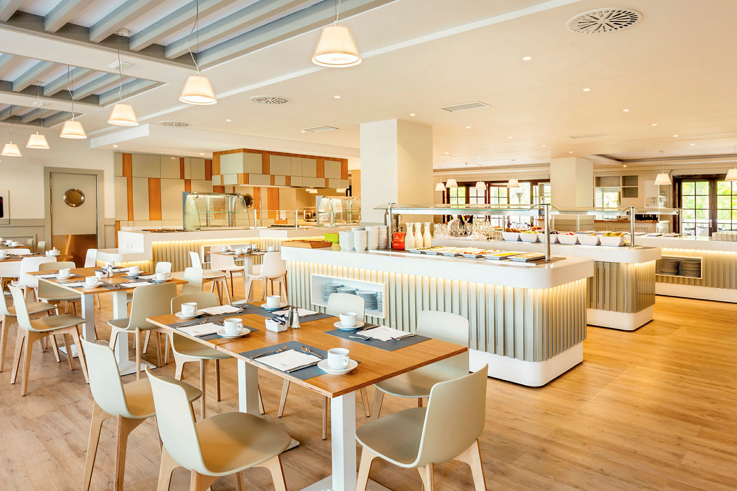 Bilde av en lys og moderne restaurant med bord, stoler og en buffédisk. (AI-generert tekst)