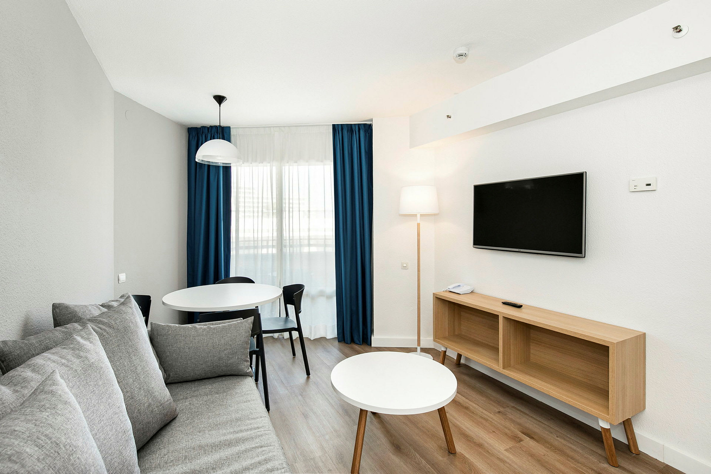 En moderne stue med sofa, spisebord og TV. (AI-generert tekst)