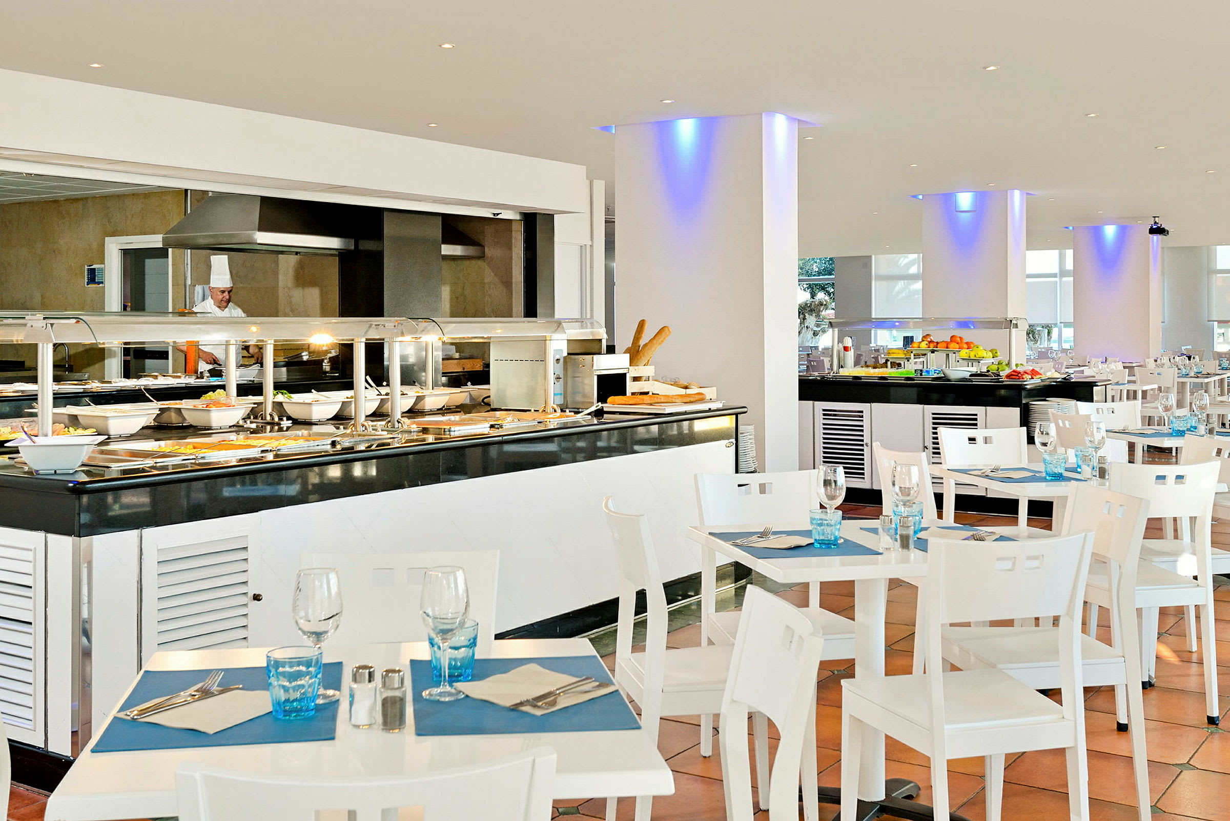 En lys og moderne bufférestaurant med dekkede bord og ulike serveringsstasjoner. (AI-generert tekst)