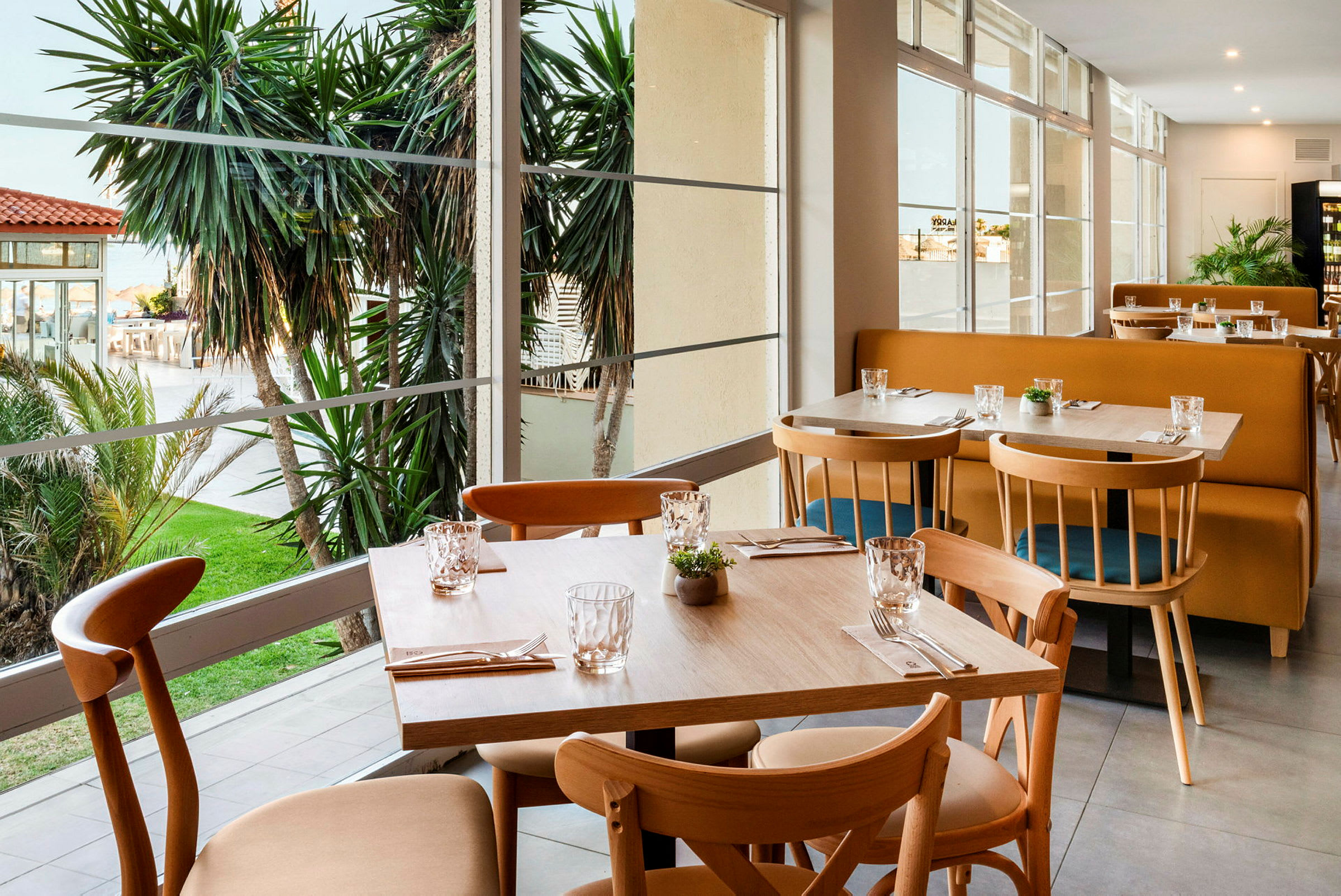 Restaurant med utsikt mot hagen og palmer. (AI-generert tekst)