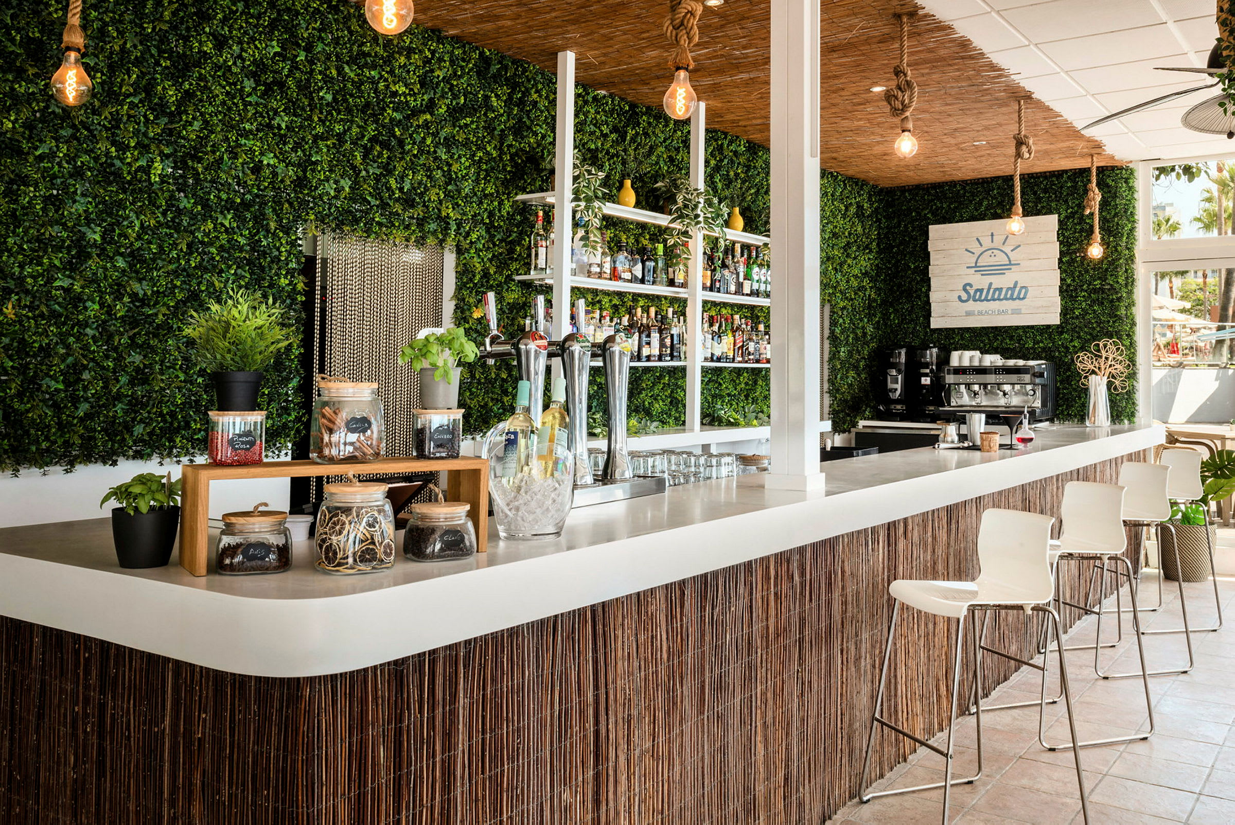 En strandbar med moderne interiør, grønn veggpynt og bardisk. (AI-generert tekst)