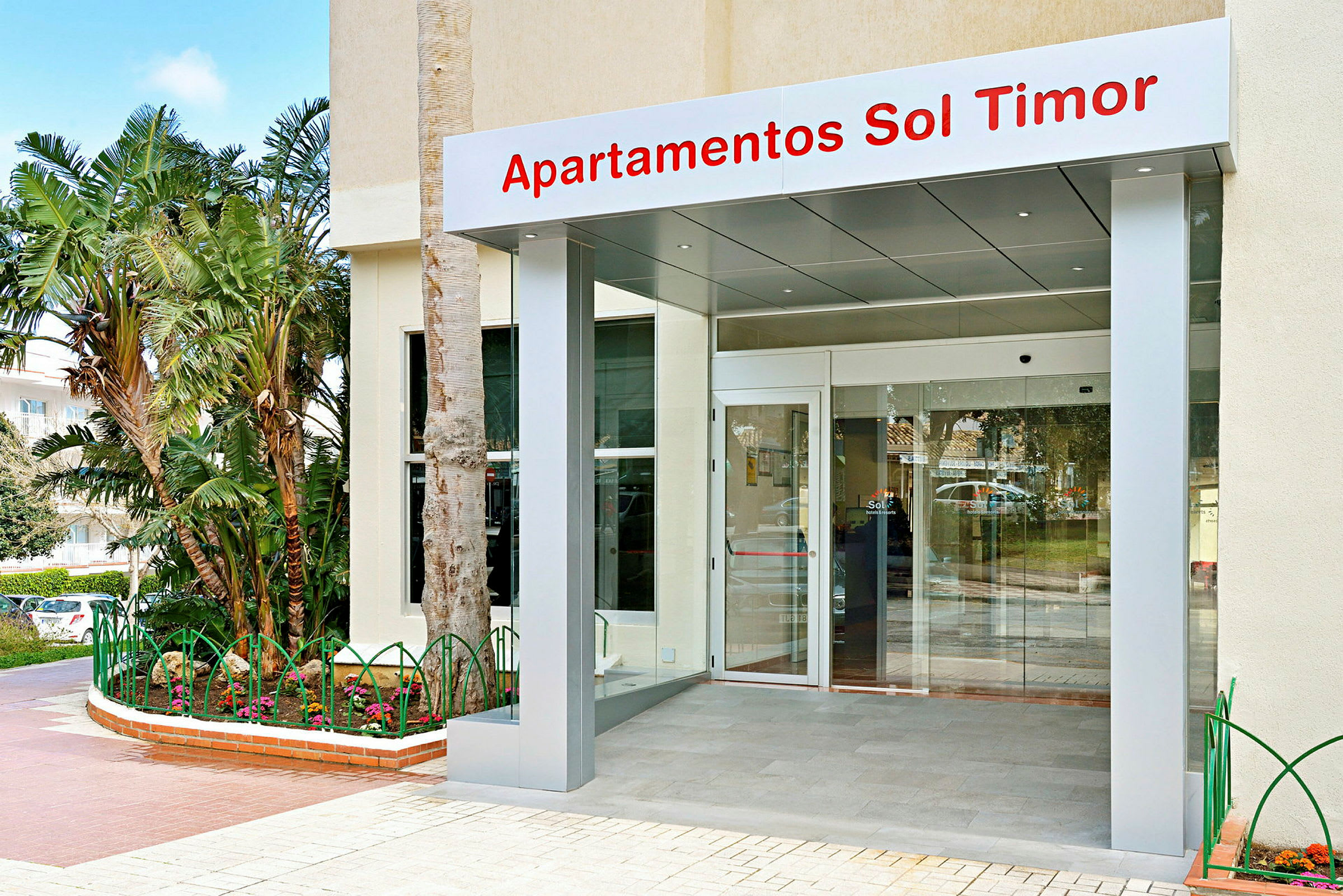 Inngangen til Sol Timor Apartments med glassdør og skilt. (AI-generert tekst)