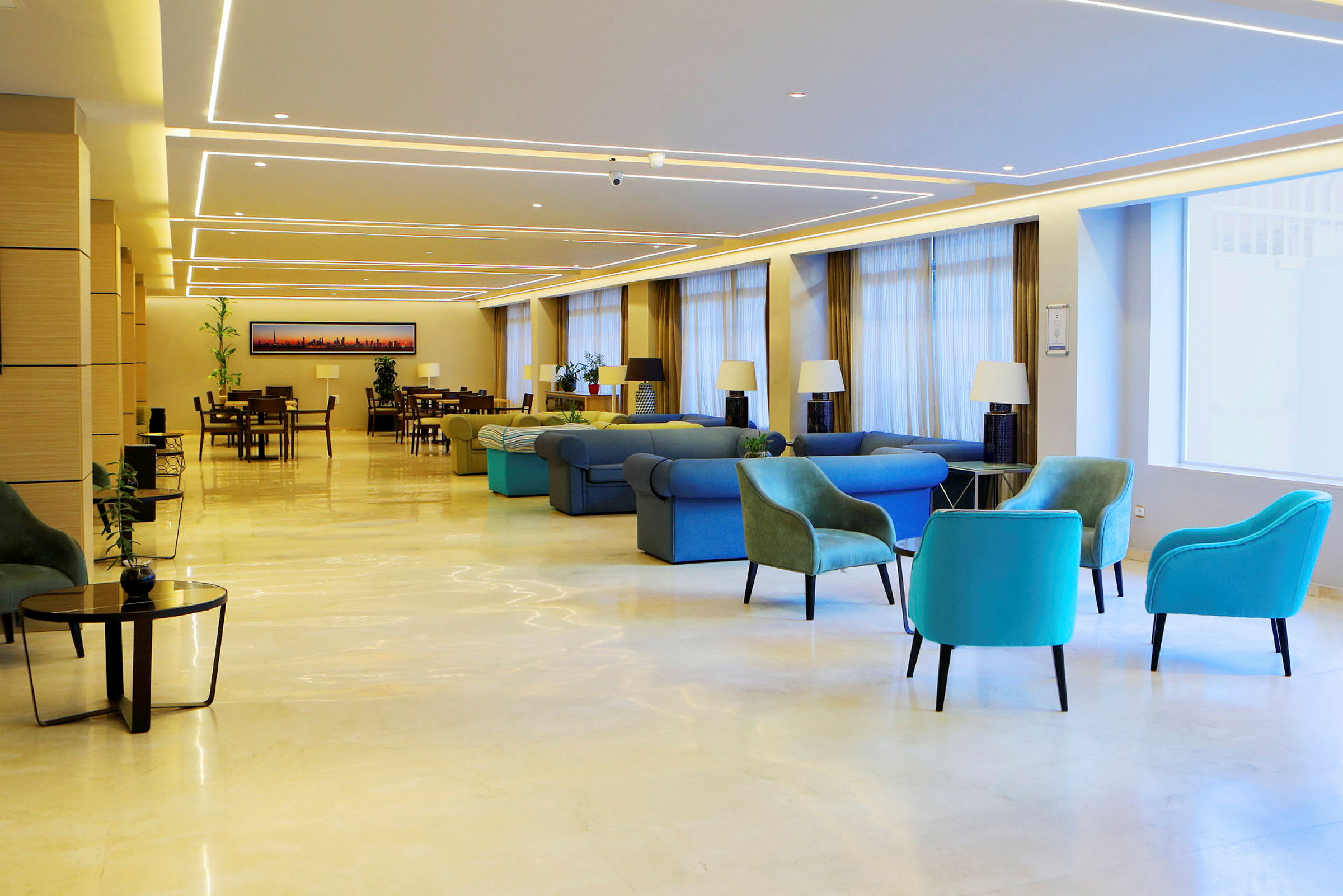 En romslig hotellobby med forskjellige sitteplasser og bord, dekorert med lamper og planter. (AI-generert tekst)