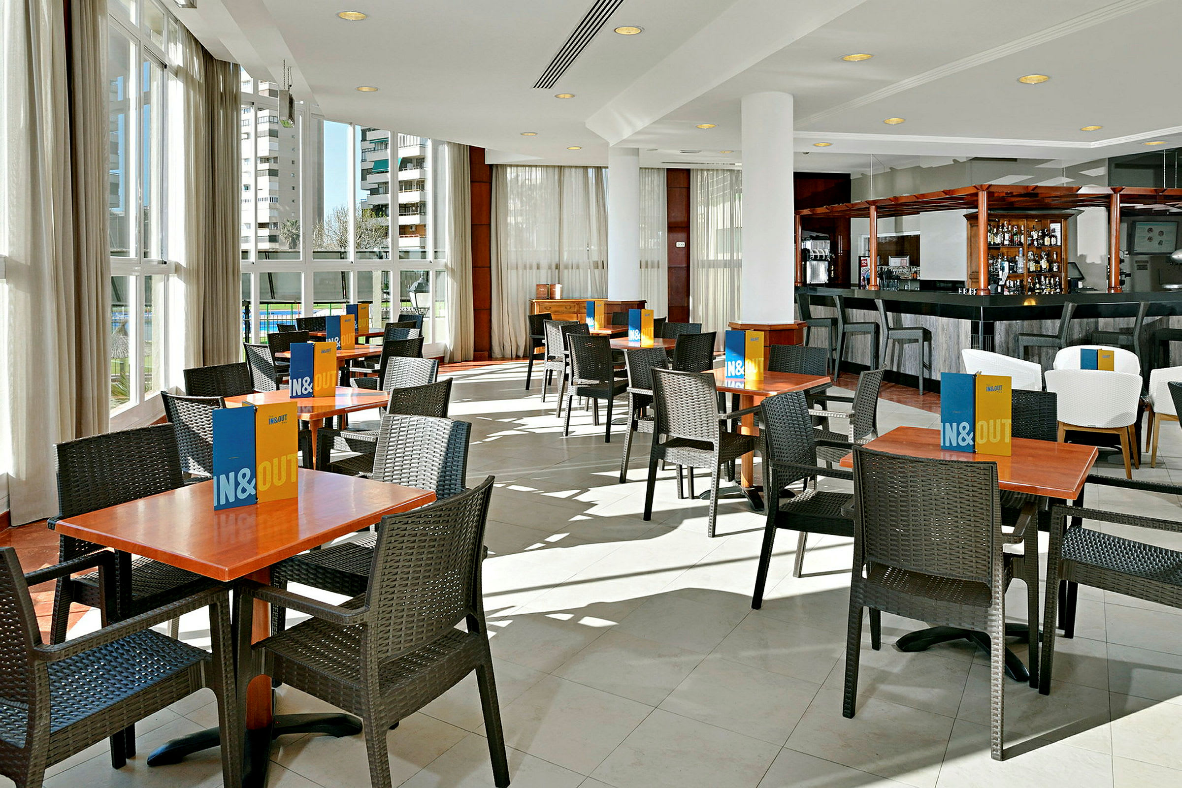 Restaurant med bord og stoler på et lyst gulv. (AI-generert tekst)