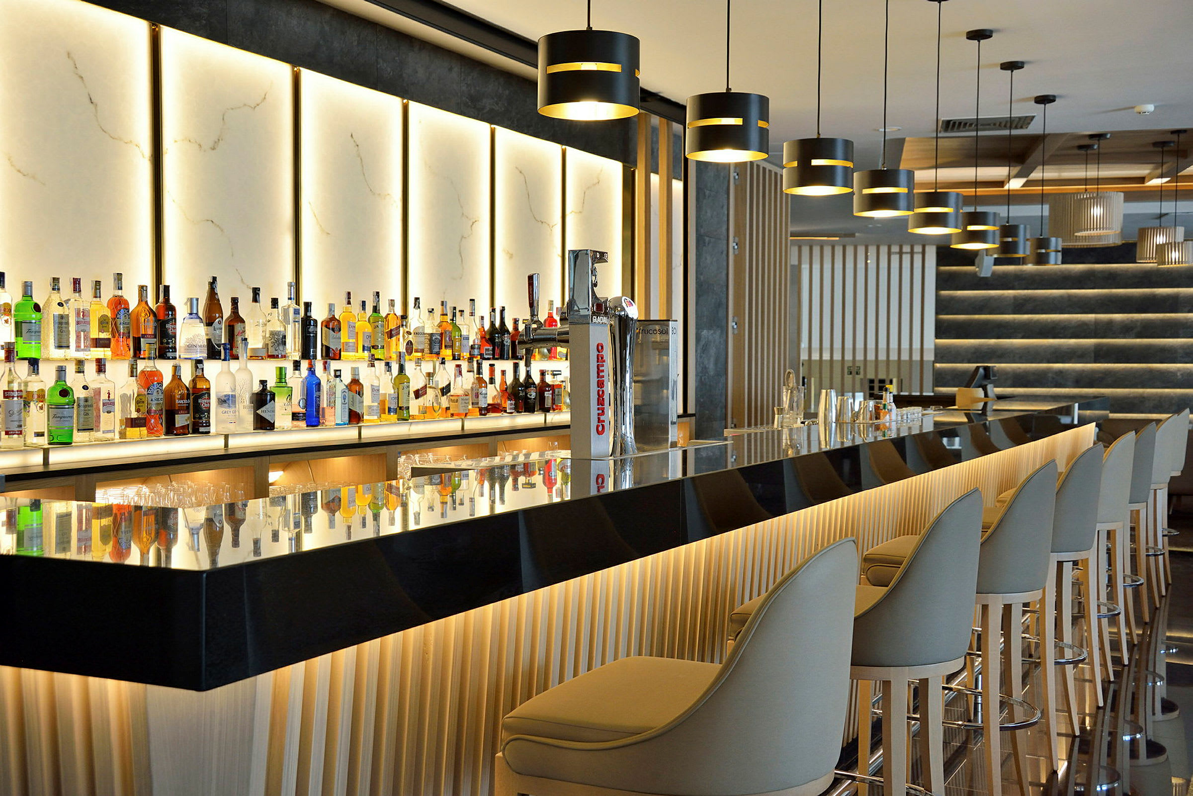 En moderne bar med opplyste flaskehyller og elegante sitteplasser. (AI-generert tekst)