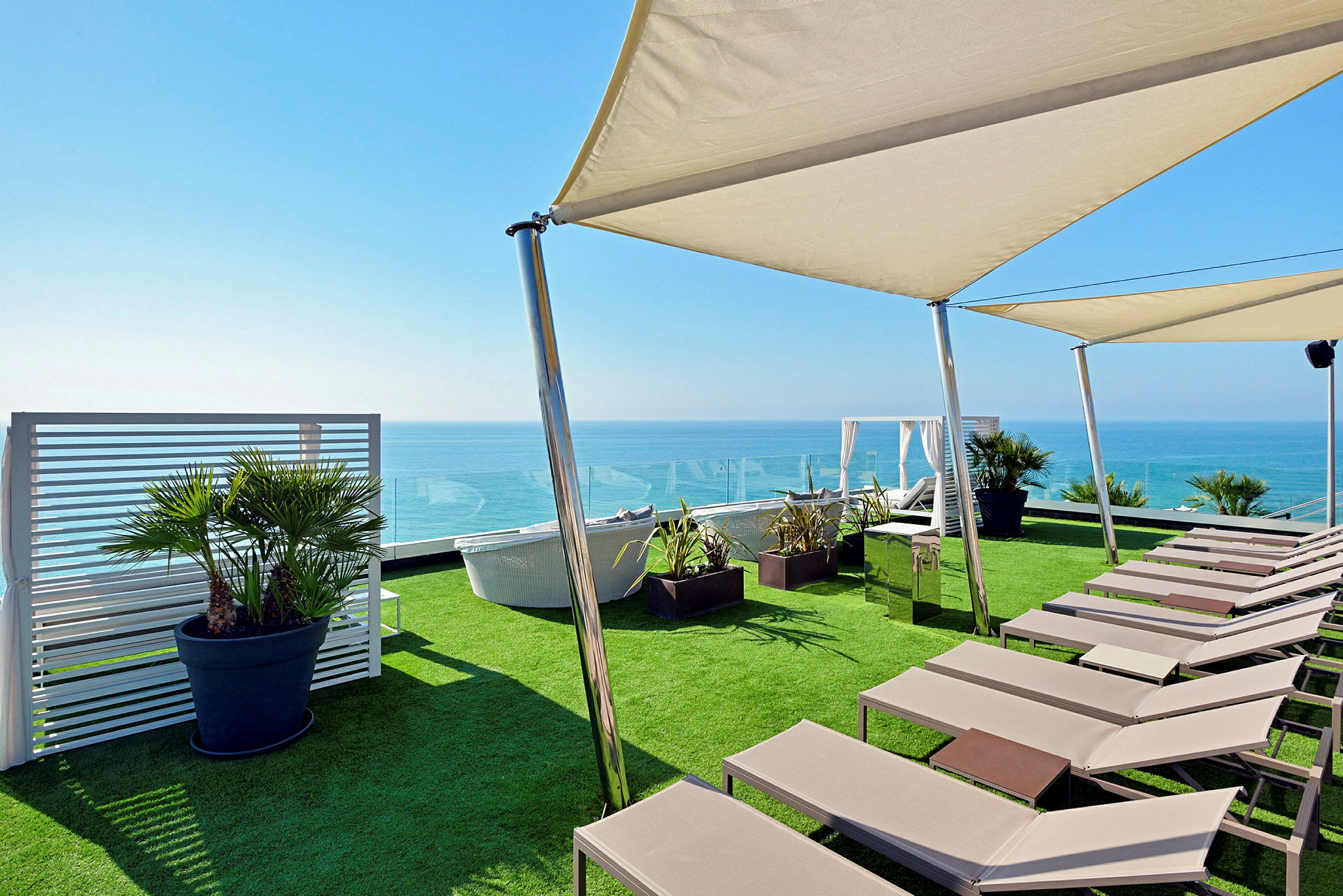 Solstoler og parasoller på en terrasse med utsikt over havet. (AI-generert tekst)