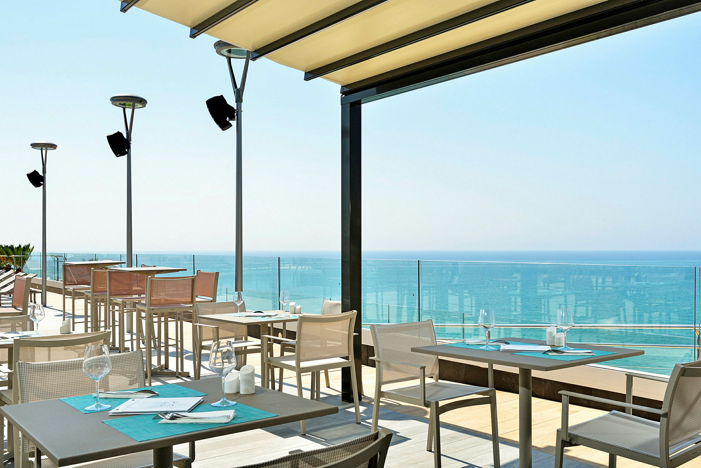 Terrasse med sitteplasser og utsikt over havet. (AI-generert tekst)